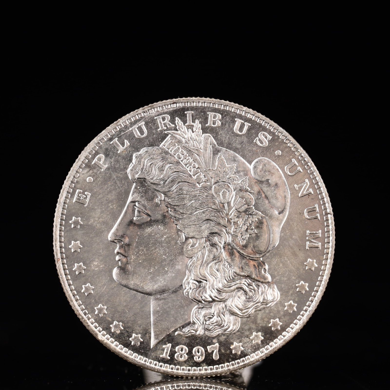 USA Morgan Dollar 1897 Coin: Obv: profile bust with date below and E PLURIBUS UNUM legend and stars around. Rev: eagle with In God we trust above within wreath with UNITED STATES OF AMERICA ONE DOLLAR legend. IN GOD WE TRUST / LI
