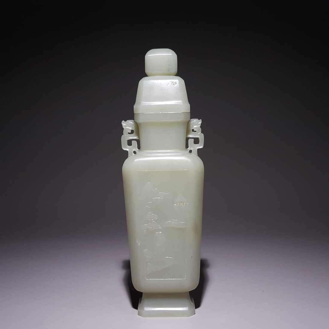 A fine Qing Dynasty Hetian jade vase with a double dragon ear cap carved with mountain viewing: Qing Dynasty Hetian jade vessel with a double dragon ear lid depicting mountain viewing SIZE: 19.5x5.9x4.2cm W:265g (The Dimensions Of All Batches Are Manually Measured.If You Need More Detailed
