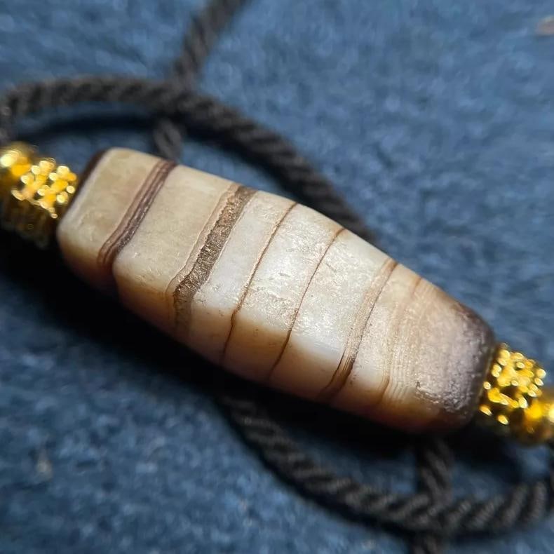 A fine Qing Dynasty Tibetan silk-wrapped agate dzi bead: A Tibetan silk-wrapped agate dzi bead from the Qing Dynasty SIZE:L:24.5mm (The Dimensions Of All Batches Are Manually Measured.If You Need More Detailed Information, Please Contact Our Customer Servic