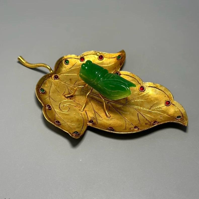 A fine Han dynasty bronze vessel gilded with a cicada leaf inlaid with gemstones: Han dynasty bronze vessel gilded with gemstones depicting cicadas on leaves SIZE: L:14.6cm W:10.5cm H:3cm (The Dimensions Of All Batches Are Manually Measured.If You Need More Detailed Information, Pl