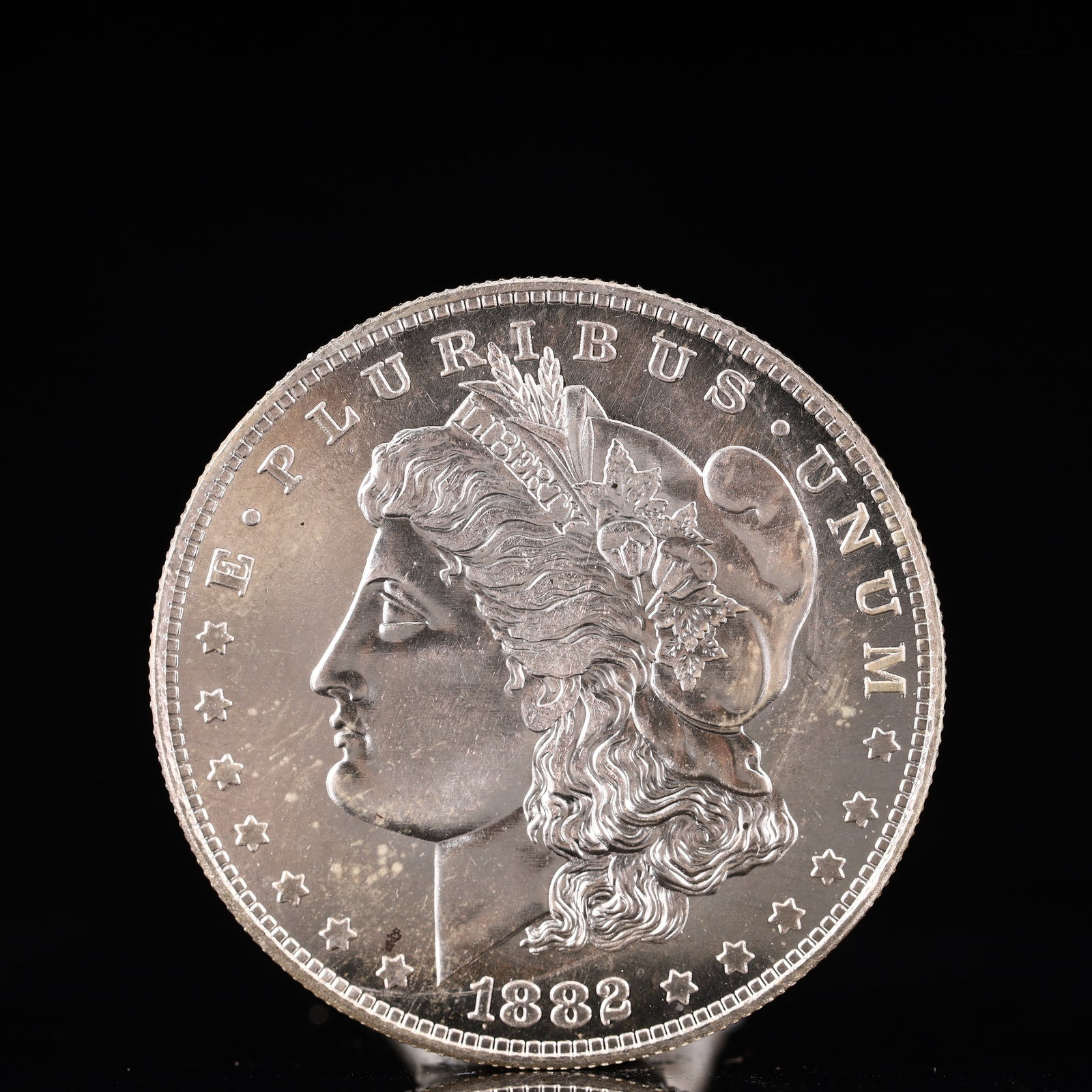 USA Morgan Dollar 1882 Coin: Obv: profile bust with date below and E PLURIBUS UNUM legend and stars around. Rev: eagle with In God we trust above within wreath with UNITED STATES OF AMERICA ONE DOLLAR legend. IN GOD WE TRUST / LI