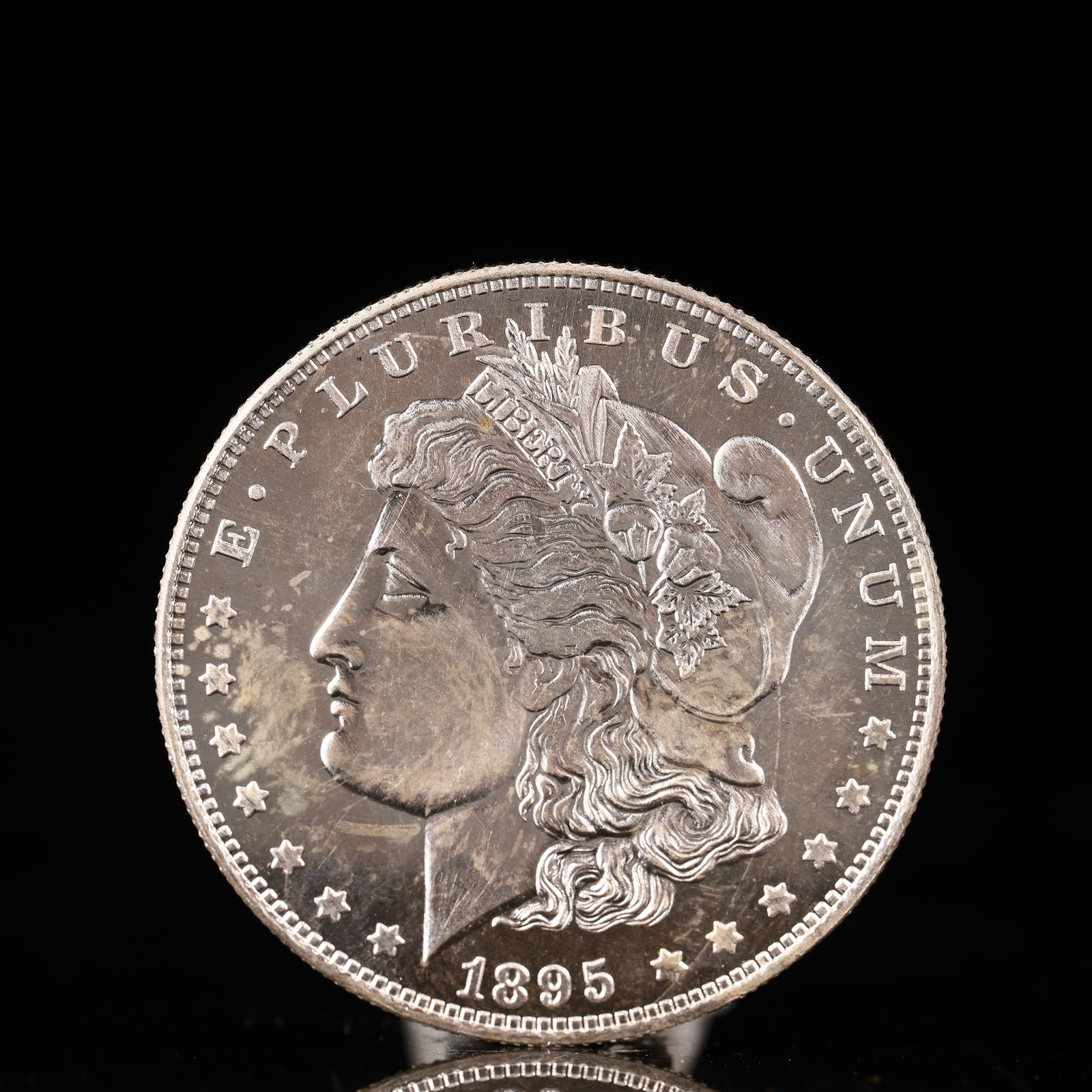 USA Morgan Dollar 1895 Coin: Obv: profile bust with date below and E PLURIBUS UNUM legend and stars around. Rev: eagle with In God we trust above within wreath with UNITED STATES OF AMERICA ONE DOLLAR legend. IN GOD WE TRUST / LI