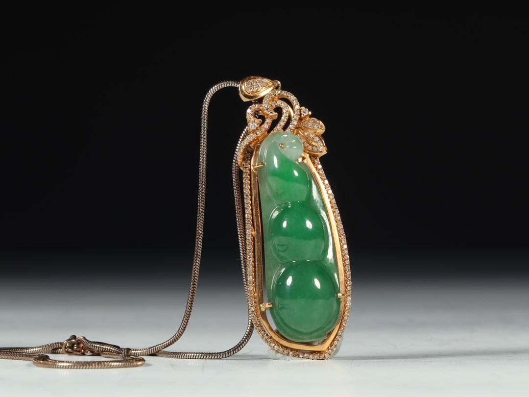 An Exquisite Jadeite Inlaid Gilt Bronze Pea Pendant: An Exquisite Jadeite Inlaid Gilt Bronze Pea Pendant Qing Dynasty, China Size:5.9cmx1.9cmx1.3cm Weight:22.5g (The Dimensions Of All Batches Are Manually Measured.If You Need More Detailed Information, 