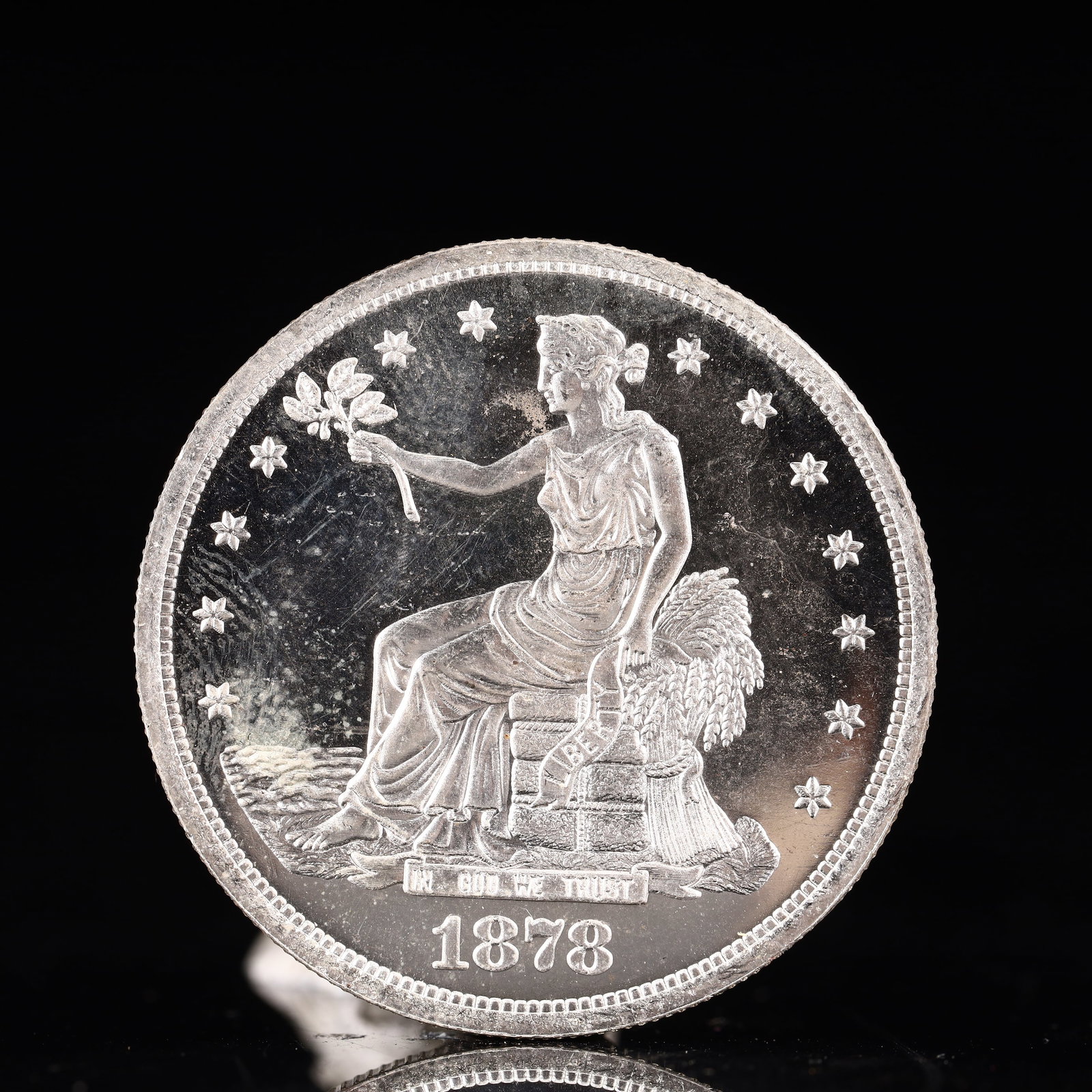 USA Trade Dollar 1878 Coin: American coin. Obverse: Liberty seated on a pedestal facing the sea to the left holding olive branches surrounded by 13 stars. IN GOD WE TRUST / LIBERTY / 1878. Reverse: An eagle holding branches with