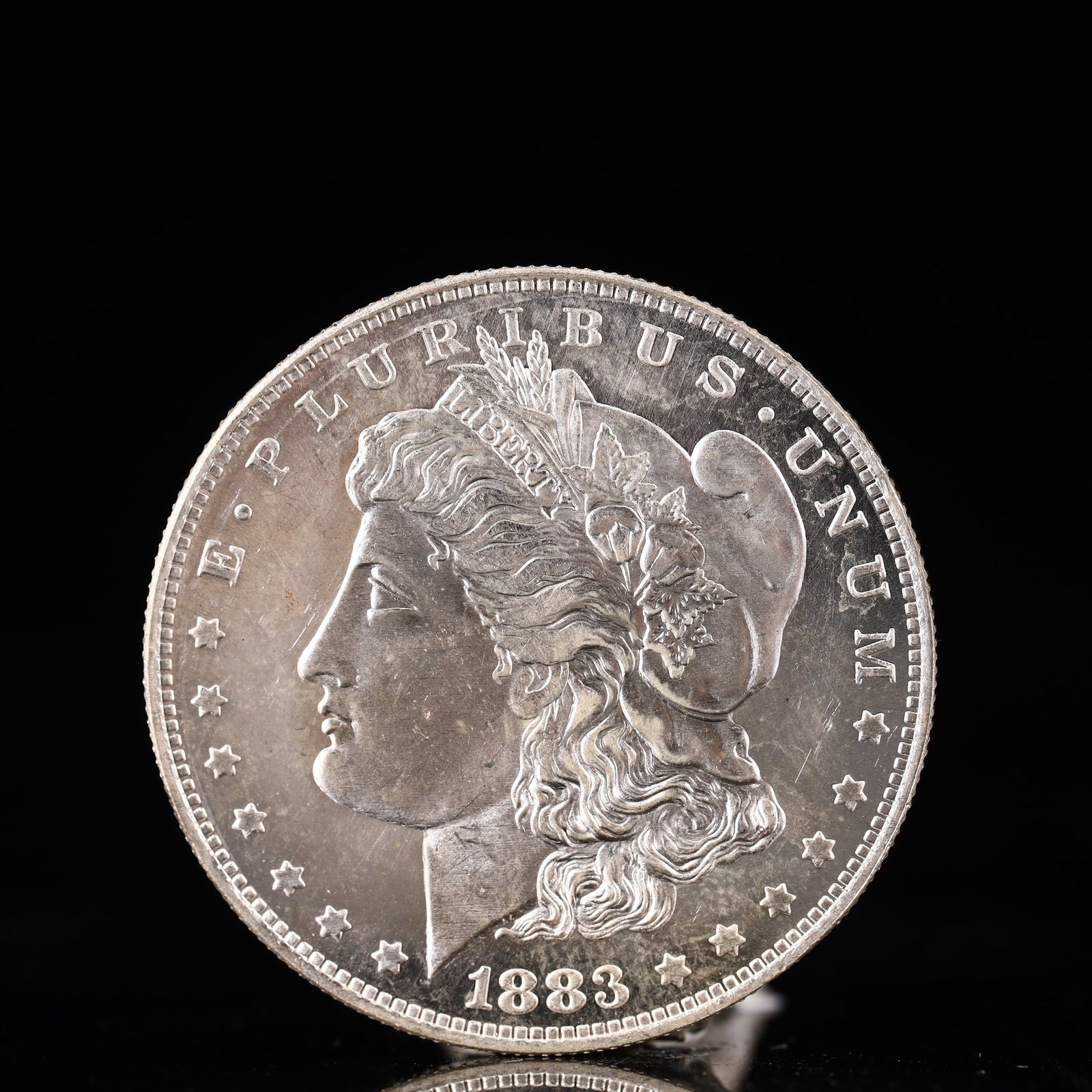 USA Morgan Dollar 1883 Coin: Obv: profile bust with date below and E PLURIBUS UNUM legend and stars around. Rev: eagle with In God we trust above within wreath with UNITED STATES OF AMERICA ONE DOLLAR legend. IN GOD WE TRUST / LI