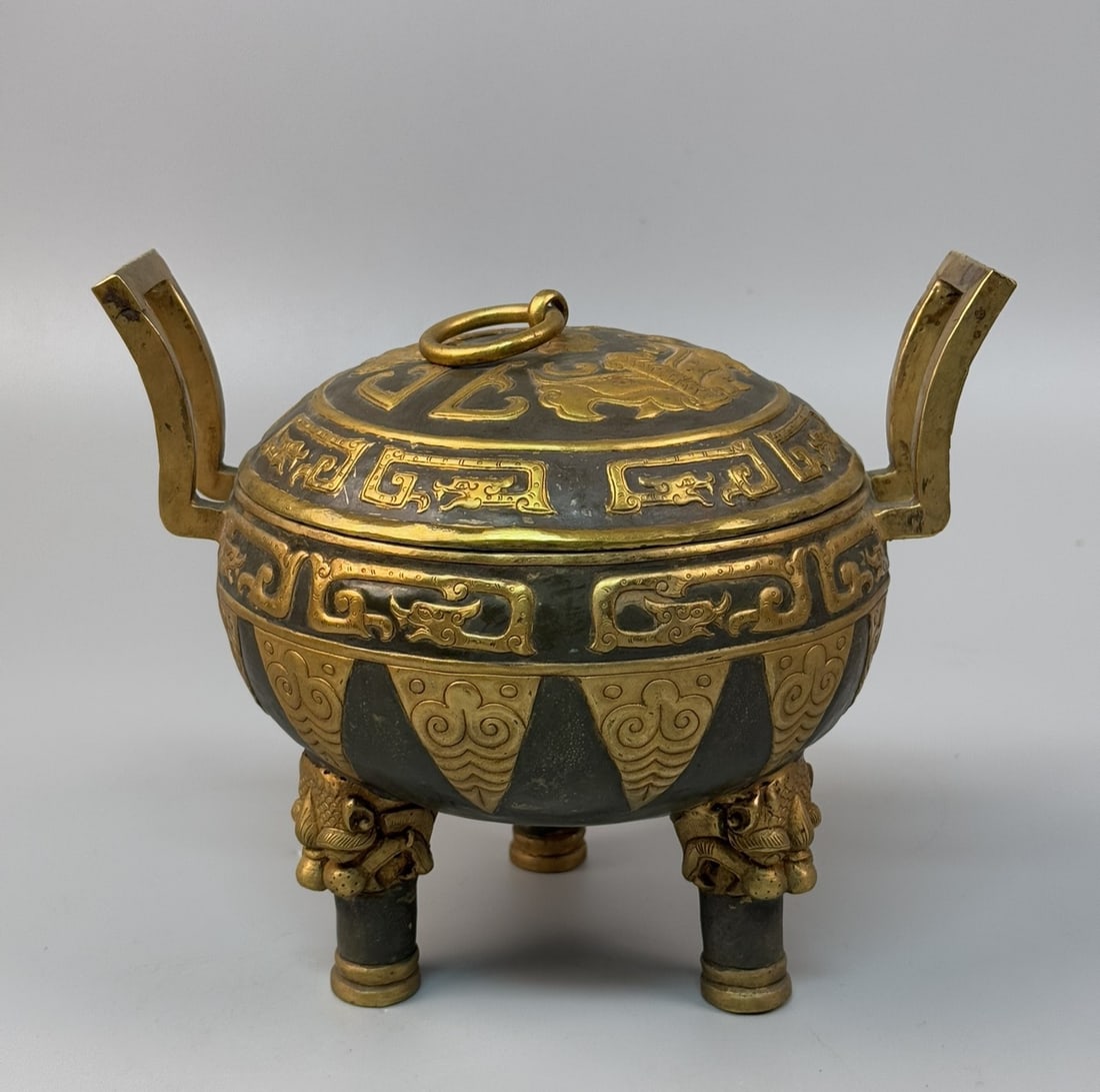 An Exquisite Gilt Bronze Beast-Face Pattern Double-Ears and Tripod Censer: An Exquisite Gilt Bronze Beast-Face Pattern Double-Ears and Tripod Censer Qing Dynasty, China Size:21cmx23cm Weight:1375g (The Dimensions Of All Batches Are Manually Measured.If You Need More