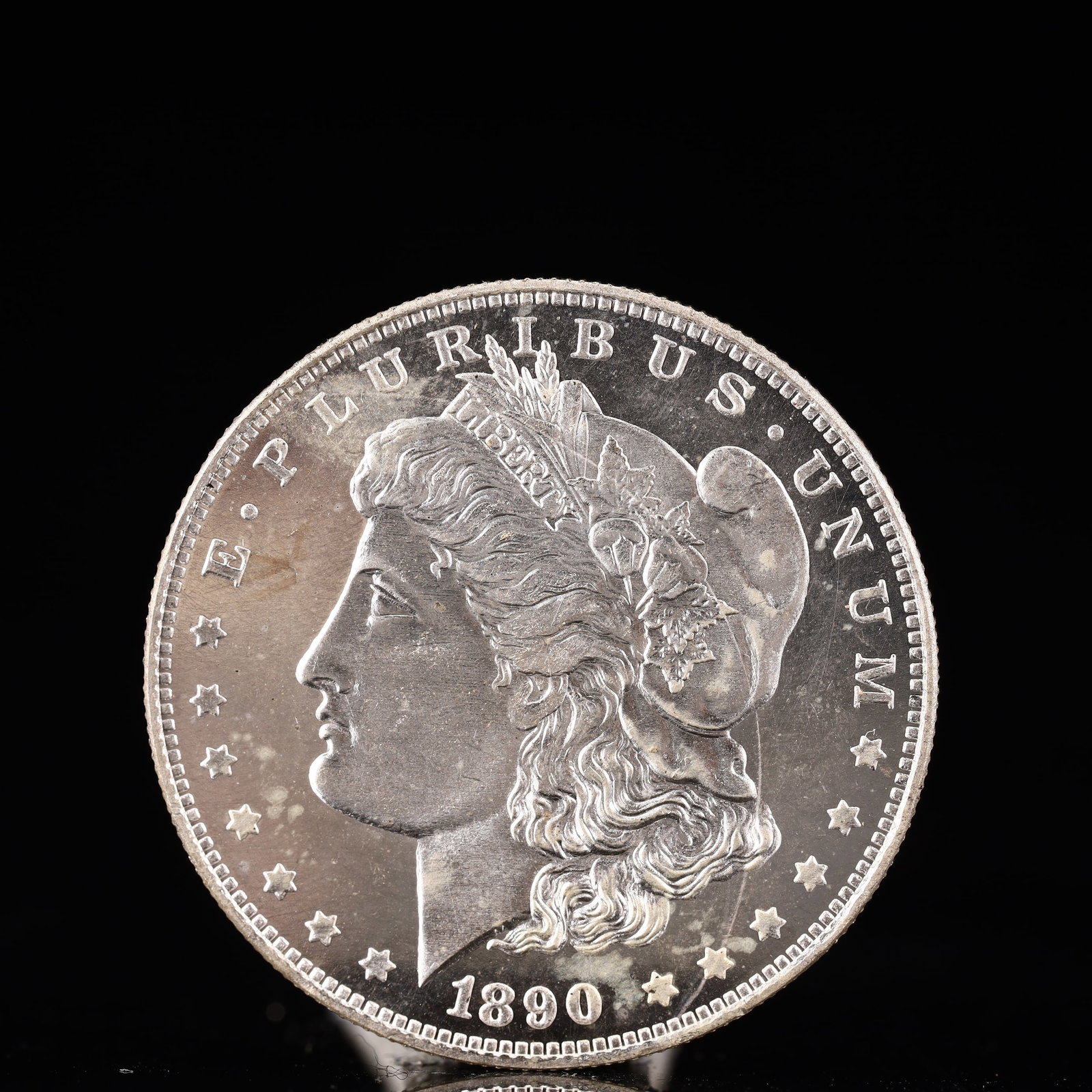 USA Morgan Dollar 1890 Coin: Obv: profile bust with date below and E PLURIBUS UNUM legend and stars around. Rev: eagle with In God we trust above within wreath with UNITED STATES OF AMERICA ONE DOLLAR legend. IN GOD WE TRUST / LI