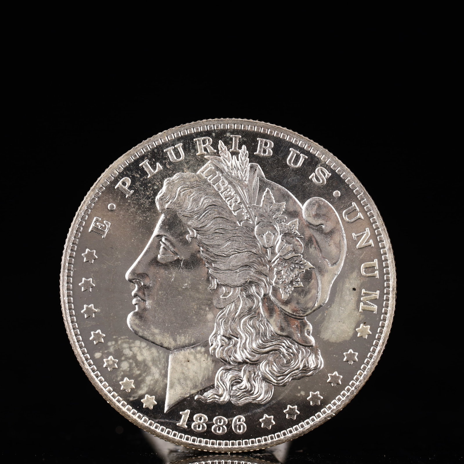 USA Morgan Dollar 1886 Coin: Obv: profile bust with date below and E PLURIBUS UNUM legend and stars around. Rev: eagle with In God we trust above within wreath with UNITED STATES OF AMERICA ONE DOLLAR legend. IN GOD WE TRUST / LI