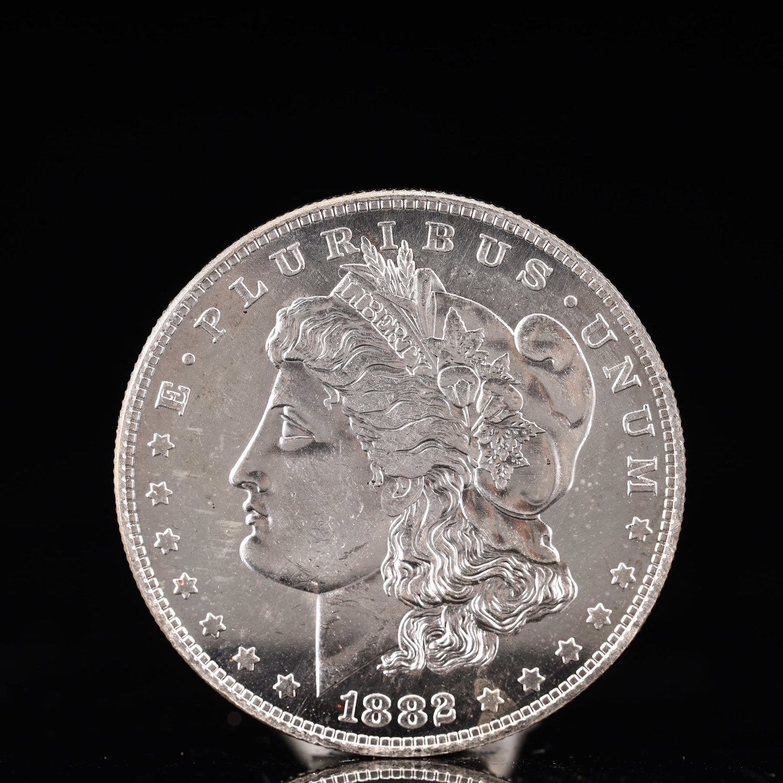 USA Morgan Dollar 1882 Coin: Obv: profile bust with date below and E PLURIBUS UNUM legend and stars around. Rev: eagle with In God we trust above within wreath with UNITED STATES OF AMERICA ONE DOLLAR legend. IN GOD WE TRUST / LI