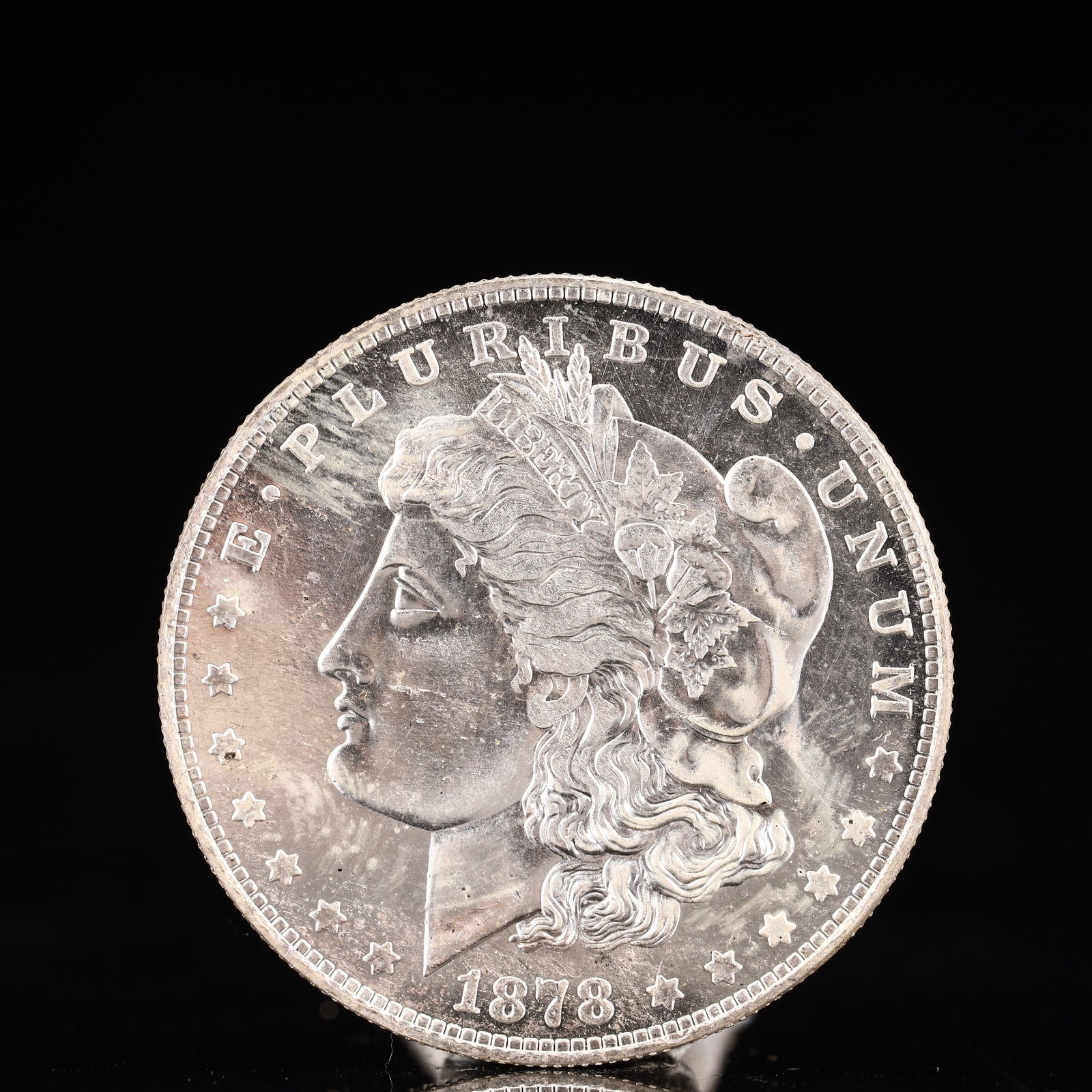 USA Morgan Dollar 1878 Coin: Obv: profile bust with date below and E PLURIBUS UNUM legend and stars around. Rev: eagle with In God we trust above within wreath with UNITED STATES OF AMERICA ONE DOLLAR legend. IN GOD WE TRUST / LI