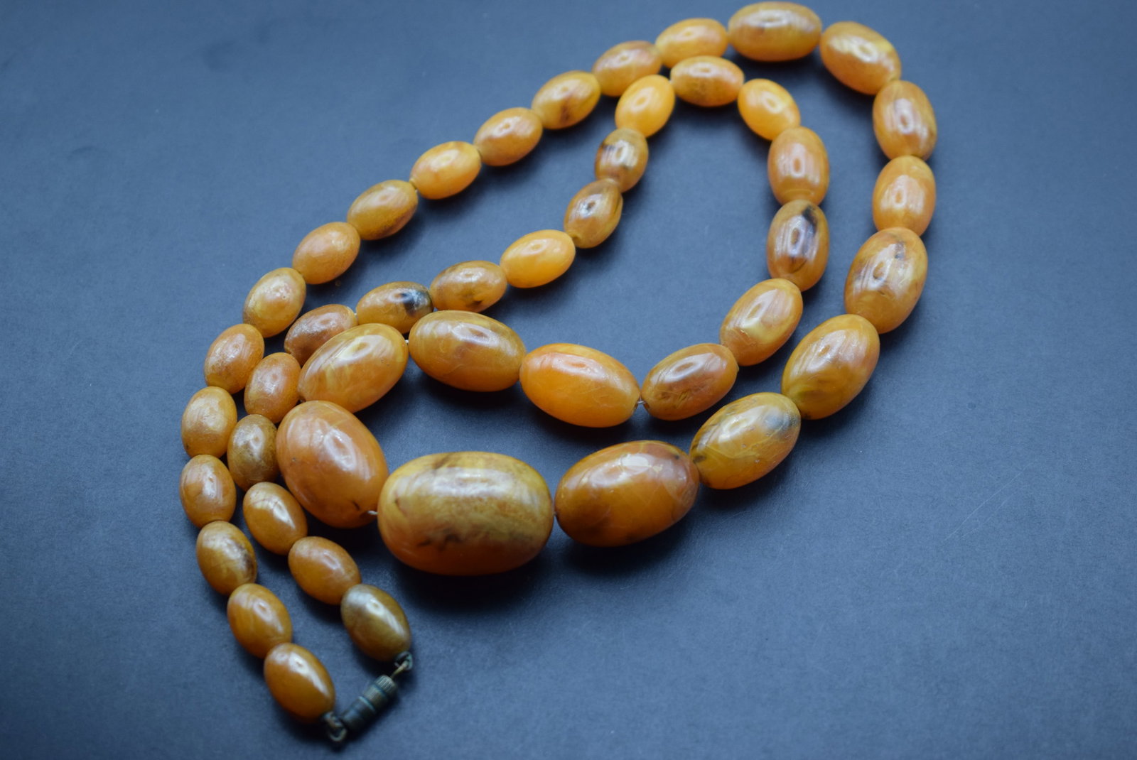 Amber Bakelite Necklace vintage graduated beads Lot 339: Amber Bakelite Necklace vintage graduated beads measures 29" long weighs 60.4 grams graduating beads from 30mm to 14mm with a barrell clasp