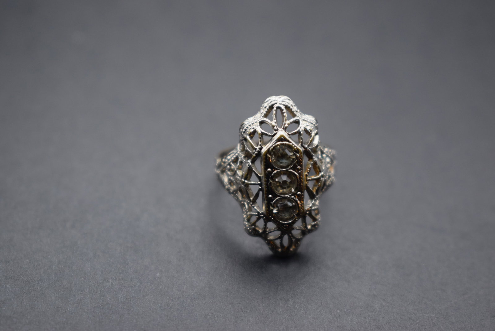 Filigree Rhinestone Ring Size 5 Vintage 1940's pot metal Lot 358: Filigree Rhinestone Ring Size 5 Vintage 1940's pot metal top measures 7/8" long with nice scrollwork and detailing all the way around