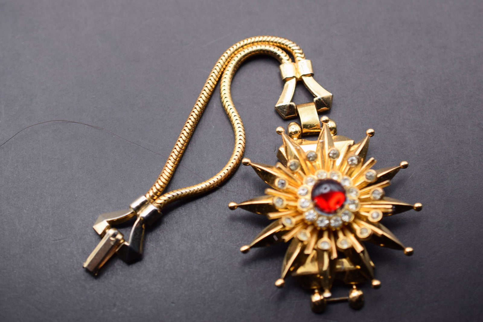 Coro 1940's Red Cabochon Starburst Bracelet Signed Lot 26: Coro 1940's Red Cabochon Starburst Bracelet Signed measures 6 1/4" long x 2" starburst signed on the back of the starburst Coro Pegasus and on the clasp Coro