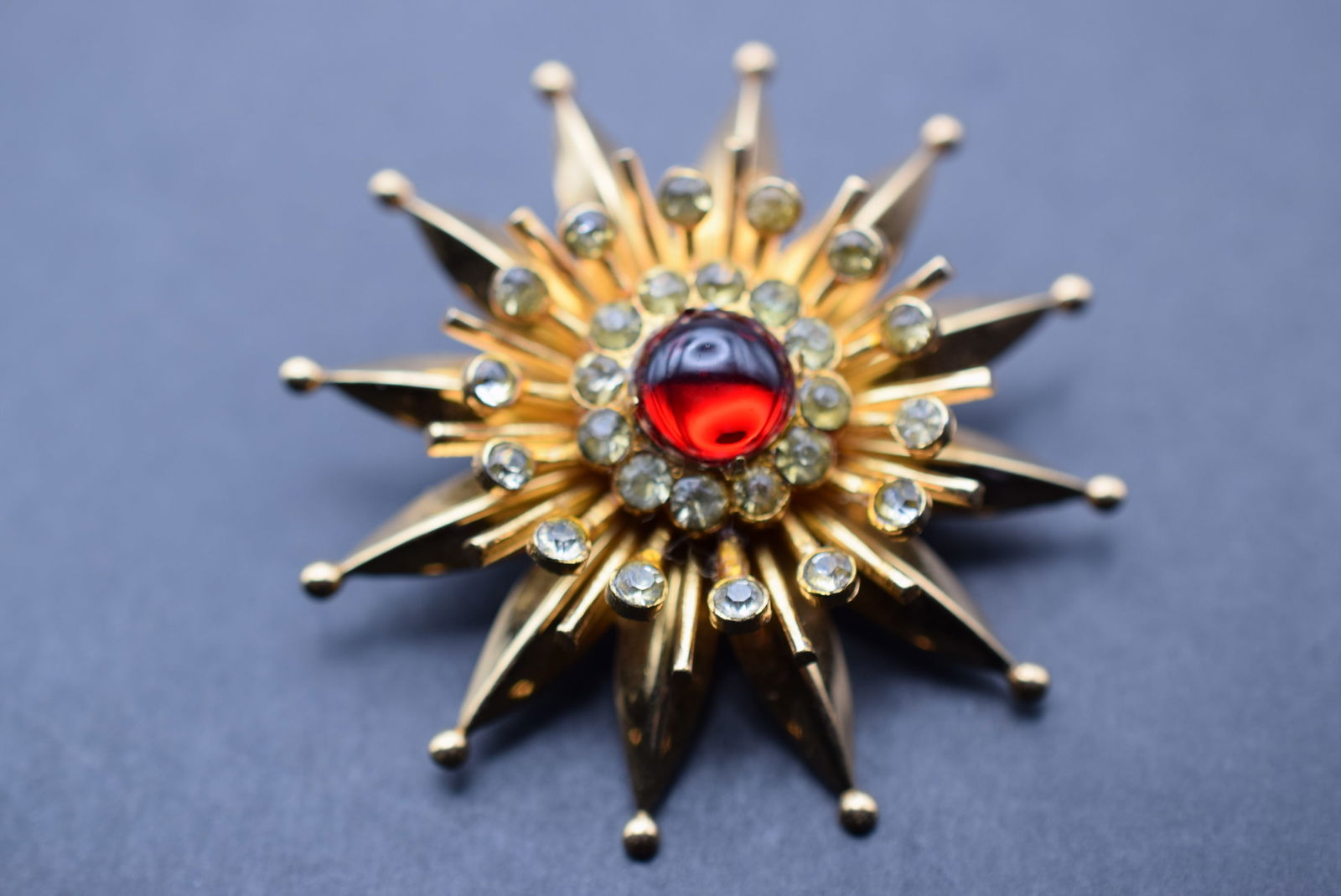 Coro 1940's Red Cabochon Starburst Brooch Signed Lot 27: Coro 1940's Red Cabochon Starburst Brooch Signed measures 2" in diameter signed on the back Coro Pegasus