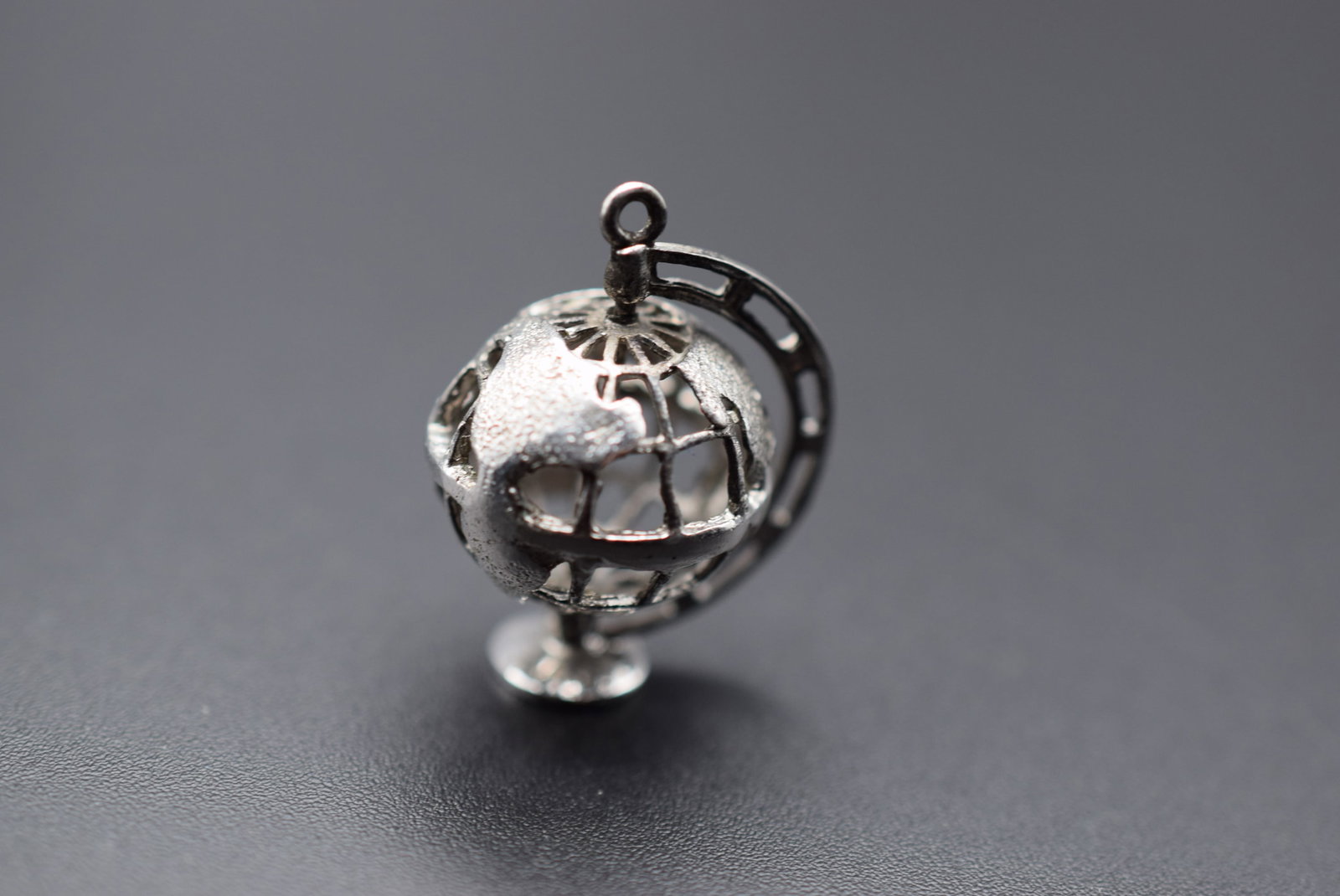 Sterling Silver 925 Moveable Spinning Globe Pendant Charm Lot 126: Sterling Silver 925 Moveable Spinning Globe Pendant Charm measures 1" x 3/4" signed Ster. on the handle of the globe and weighs 4.49 grams