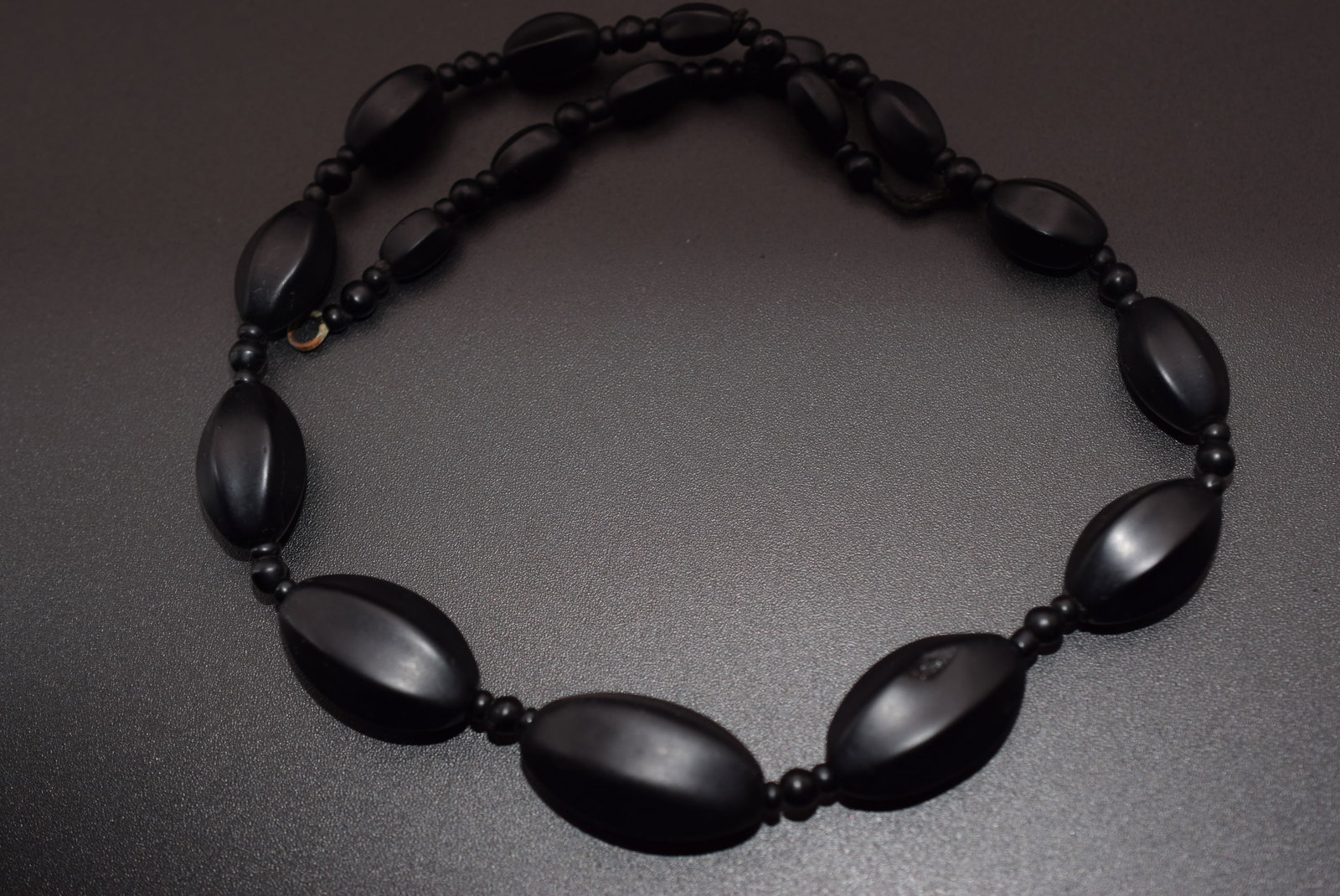 Satin Finish Jet Necklace Vintage Lot 793: Satin Finish Jet Necklace Vintage measures 16" long beads measure oblong beads 9mm to 26mmmissing the hook end of the clasp needs to be re strung or fixed