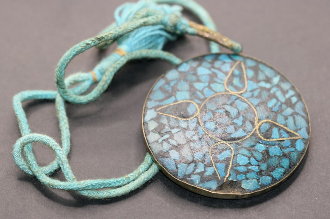 India Vintage Brass Medallion Pendant inlaid Turquoise Lot 877: India Vintage Brass Medallion inlaid Turquoise measures pendant 3/8" chip in bottom Turquoise rope 26" long signed India on the back