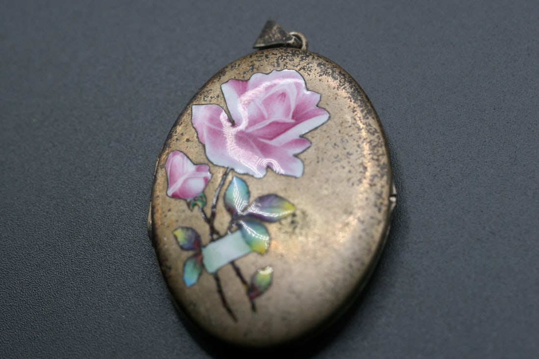 Enamel Hand Painted Locket Vintage 1940's with original photos .Lot#209: Enamel Hand Painted Locket Vintage 1940's with original photos measures 2 1/8" x 1 5/8" some wear commensurate with age, opens and closes well.