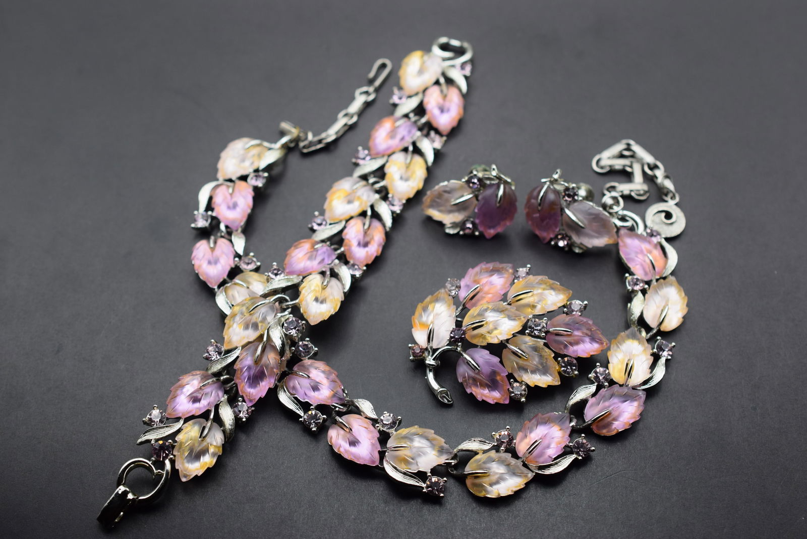 Lisner Outstanding Thermo Plastc Pink Leaves Full Parure Lot 85: Lisner Outstanding Thermo Plastc Pink Leaves Full Parure Bracelet Measures 7 3/8" x 7/8" signed Lisner on the clasp and the matching Brooch Measures 2 1/8" x 1 5/8" signed on the back Lisner and the m