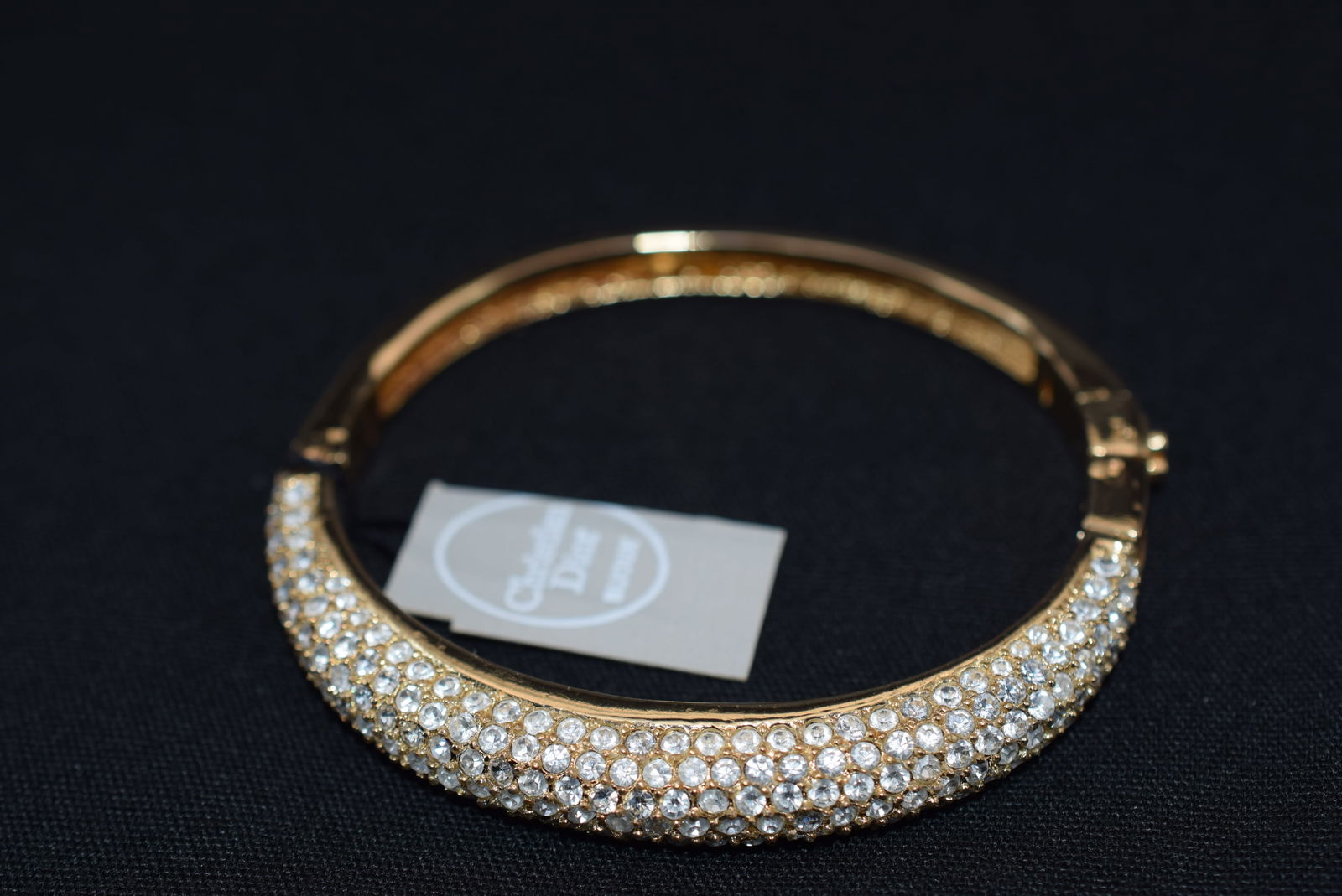 Dior Bracelet Pave Rhinestone Hinged With Original Tags ! Lot 903: Dior Bracelet Pave Rhinestone Hinged With Original Tags ! measures 2 1/4" across the inside and is hinged for easy on off. Has the original Vintage Hang Tag ! Never worn, signed inside and on the clas