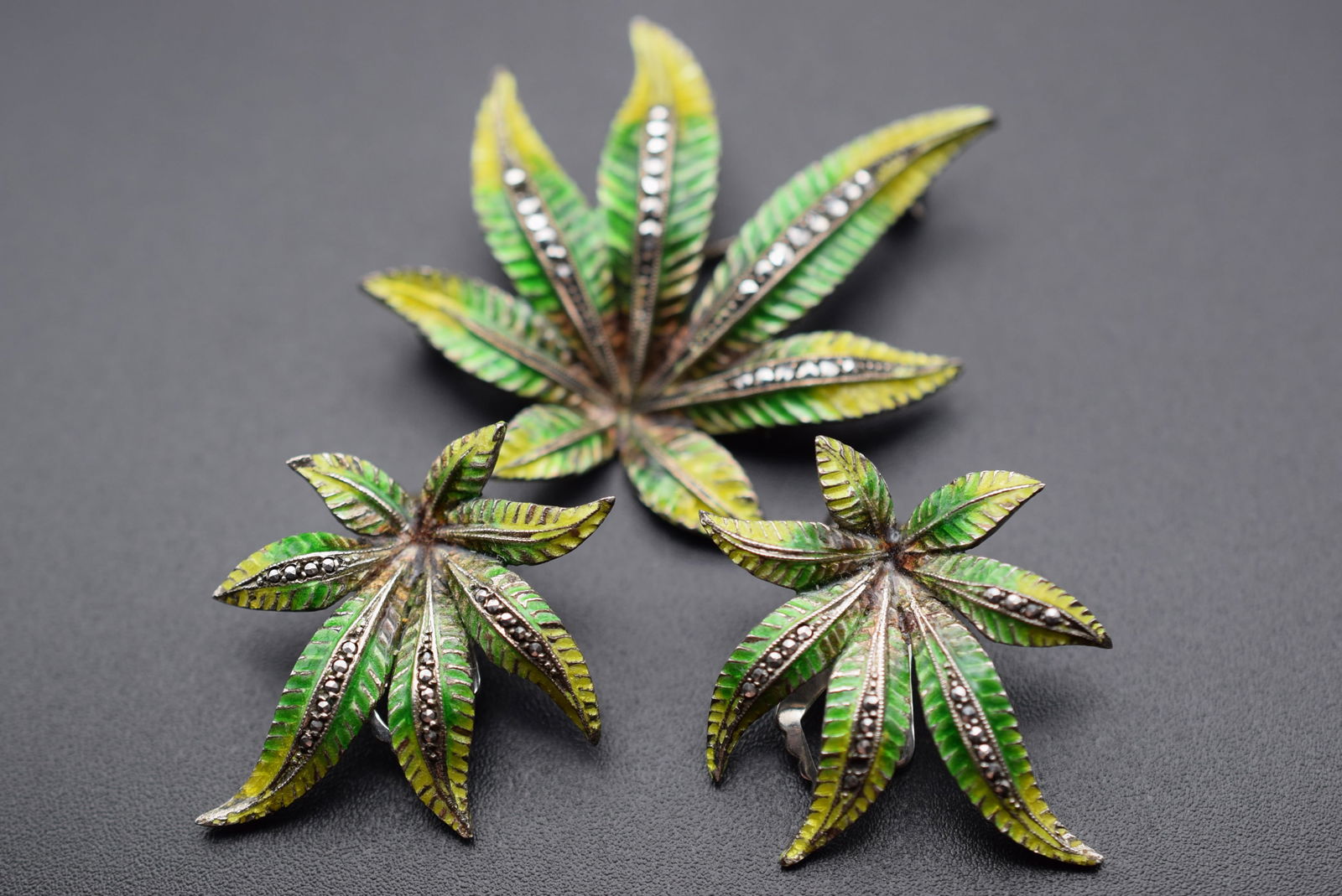 Marijuana Sterling Silver 925 Enamel Marcasite Brooch Clip Earrings Vintage Lot# DG 927: Marijuana Sterling Silver 925 Enamel Marcasite Brooch Clip Earrings Vintage measures 2" x 1 3/4" clip earrings 1 3/8" x 1 1/4" signed DIV Sterling and sterling on all pieces weighs 20.12 grams