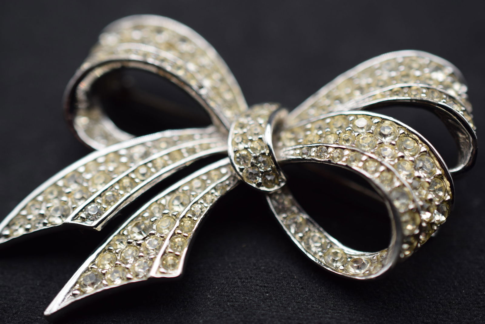 Boucher Bow Brooch Rhinestone Vintage Signed numbered Lot 1131: Boucher Bow Brooch Rhinestone Vintage Signed numbered measures 2 3/8" x 1 3/4" stones appear yellowish in the photos but they are not - signed Boucher 6222