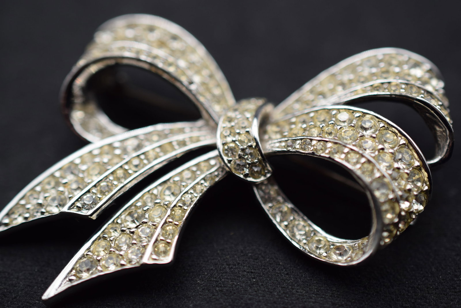 Boucher Bow Brooch Rhinestone Vintage Signed numbered Lot 1131: Boucher Bow Brooch Rhinestone Vintage Signed numbered measures 2 3/8" x 1 3/4" stones appear yellowish in the photos but they are not - signed Boucher 6222