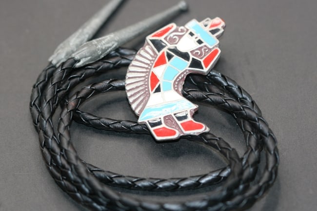 Native Inlaid enamel Bolo Lot 525: Native Inlaid enamel Bolo center measures 2" x 1" and the leather bolo measures 36" long hanging at 18"
