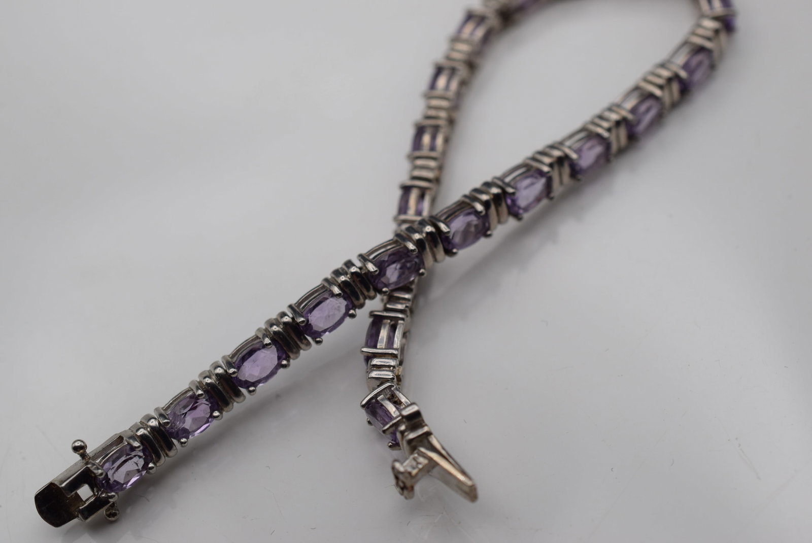 Amethyst CZ Sterling Silver 925 Tennis Bracelet Lot EH 884: Amethyst CZ Sterling Silver 925 Tennis Bracelet measures 7 3/8" x 1/4" signed 925 weighs 13.19 grams closes well but missing the swining safety catch so it doesnt stay closed without it,