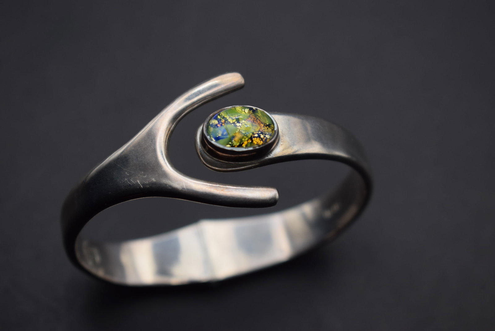 DMP 925 IM-02 Sterling Bracelet 53.2 g Lot 396: DMP 925 IM-02 Sterling Bracelet 53.2 g has an immitation foiled opal hinged measures 2 1/2" across very heave and thick and is 1 1/4" at the widest point