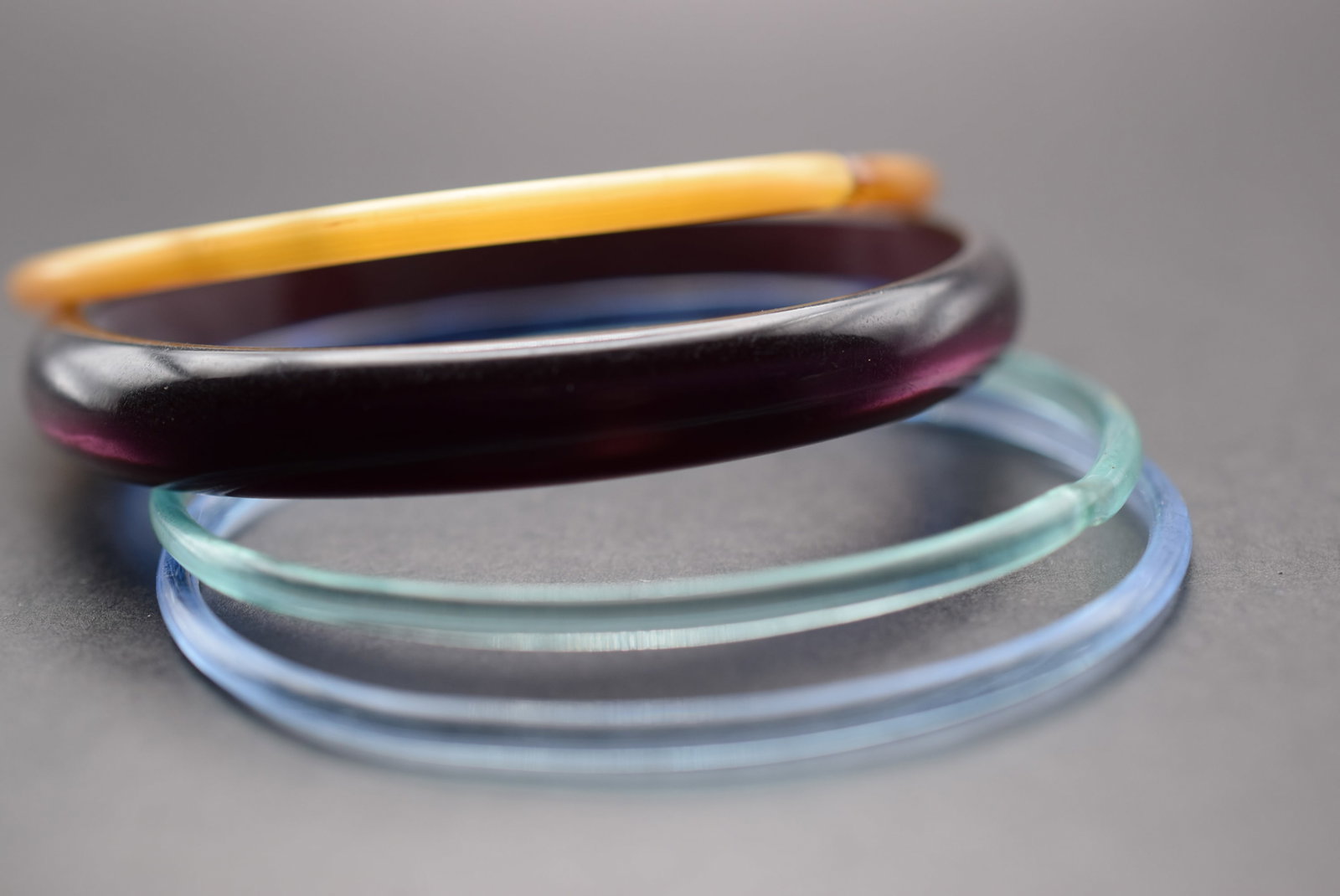 Vintage Glass and Plastics 1940's Bangles Lot 827: Vintage Glass and Plastics 1940's Bangles purple is plastic the other 4 are glass and frosted glass inside measures between 2 1/2" across to 2 3/8" across