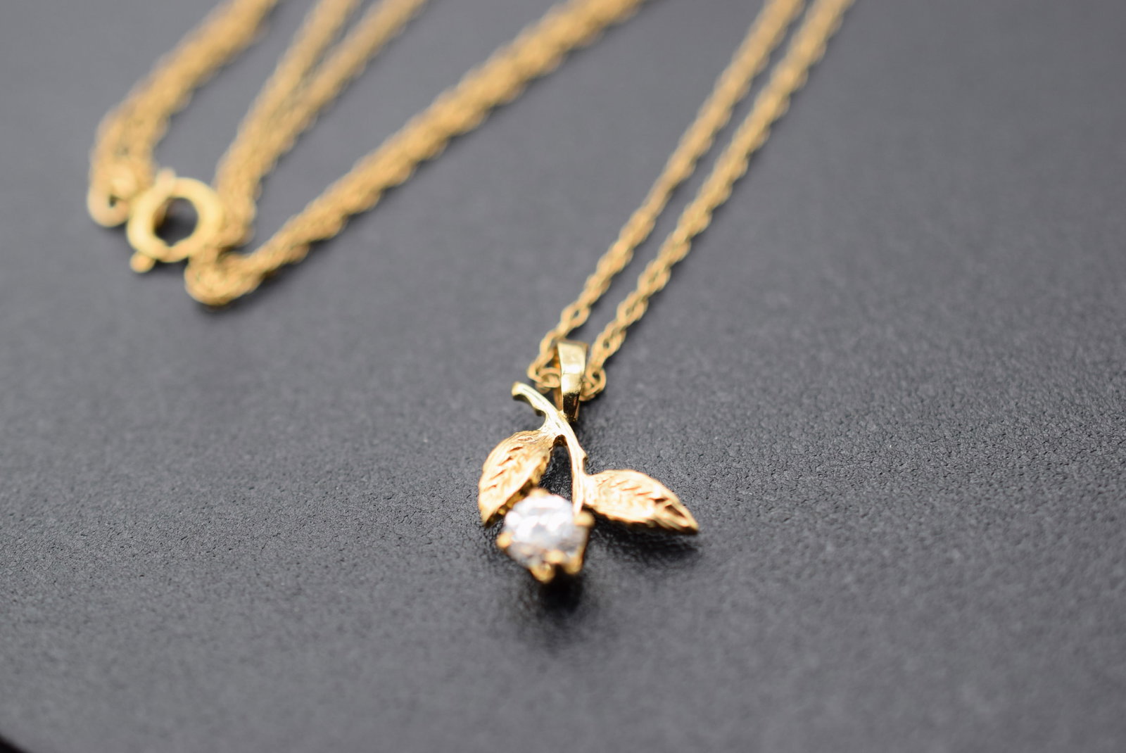 CZ Cubic Zirconia stone in a 14K Gold Filled Chain Necklace Lot 997: CZ Cubic Zirconia stone in a 14K Gold Filled Chain measures 18" long Pendant measures 5/8" x 1/2" Chain is signed 1 /20 14K Gold Filled