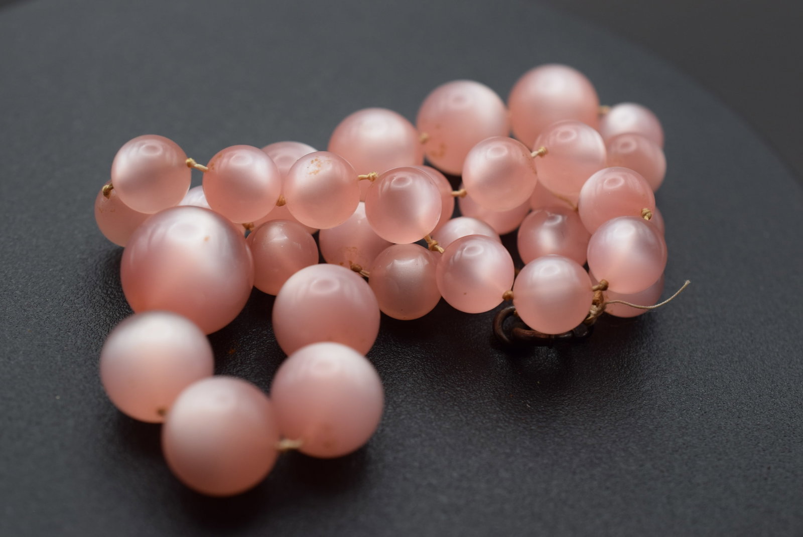 Pink Lucite Knotted Bead Necklace 1940's vintage Lot 1189: Pink Lucite Bead Necklace 1940's vintage measures 18" long beads measure between 9mm and 15mm knotted and has an old spring ring clasp