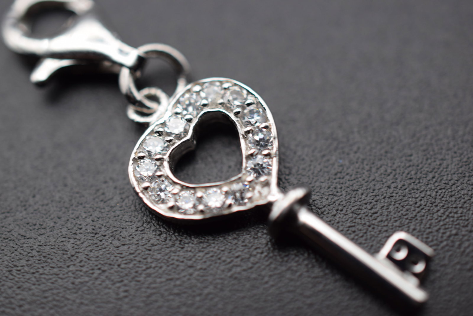 CZ Crown Key Pendant Charm Sterling Silver 925 Lot 155: CZ Crown Key Pendant Charm Sterling Silver 925 measures 1" x 3/8" plus the bale and is signed 925 on the bale and on the back of the key weighs 1.95 grams