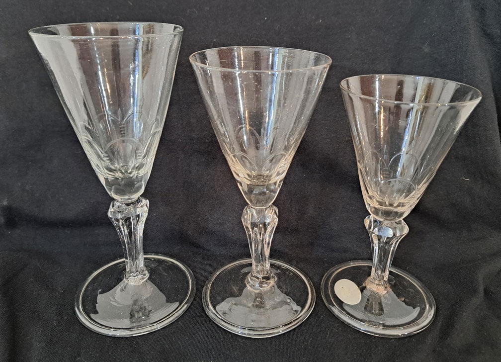 Lot of Three Early Wine Glasses: Largest is 7" Tall X 3 1/8" Foot. Smallest is 6 3/4" Tall X 3" Foot.