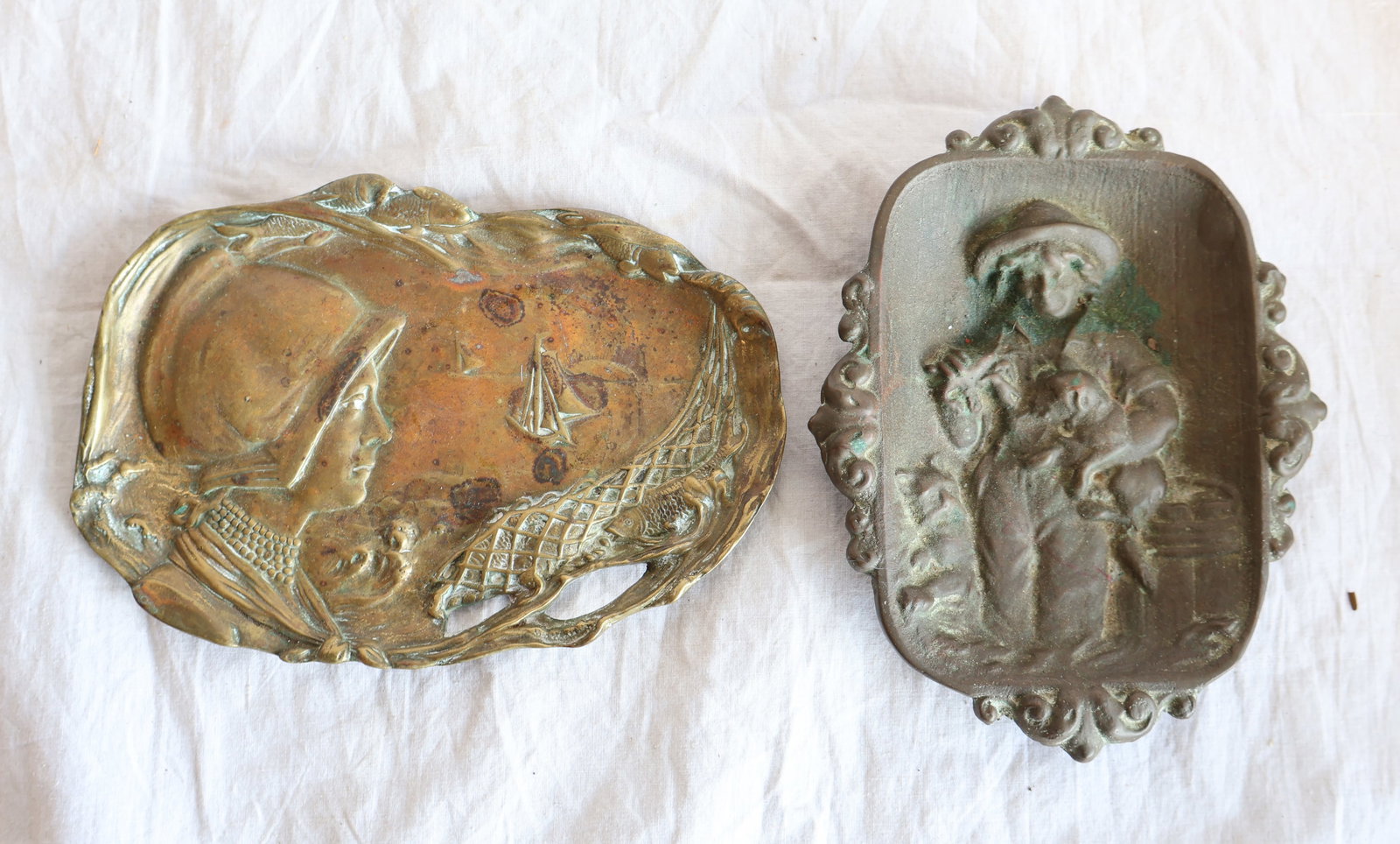 Lot of Two Bronze Trays- Nautical Themed: Girl with Lobster, Dog and Cat: 6" x 4 3/4" Girl in Bonnet with Fish and Net: 6" x 4 3/4" Gurley Auction Company provides In House Packing and Shipping and strive to keep costs as reasonable as possib