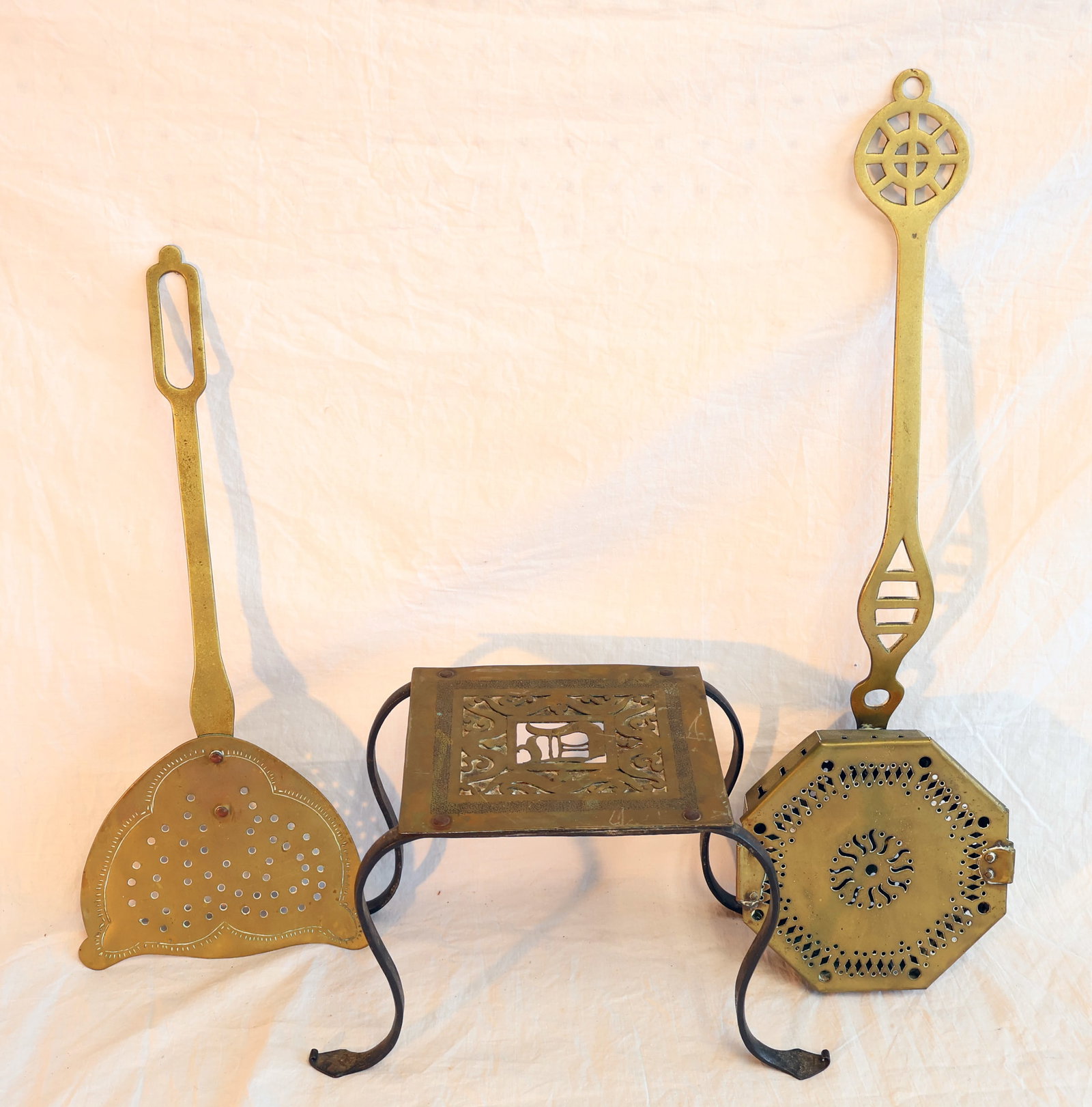 Lot of Three Brass Items; Wrought Iron and Brass Footman, Skimmer, and Roaster: Footman: 7 1/2" x 6" x 10" Skimmer: 17 1/2" x 7" Roaster: 22" x 7" x 2" Gurley Auction Company provides In House Packing and Shipping and strive to keep costs as reasonable as possible. Please take th
