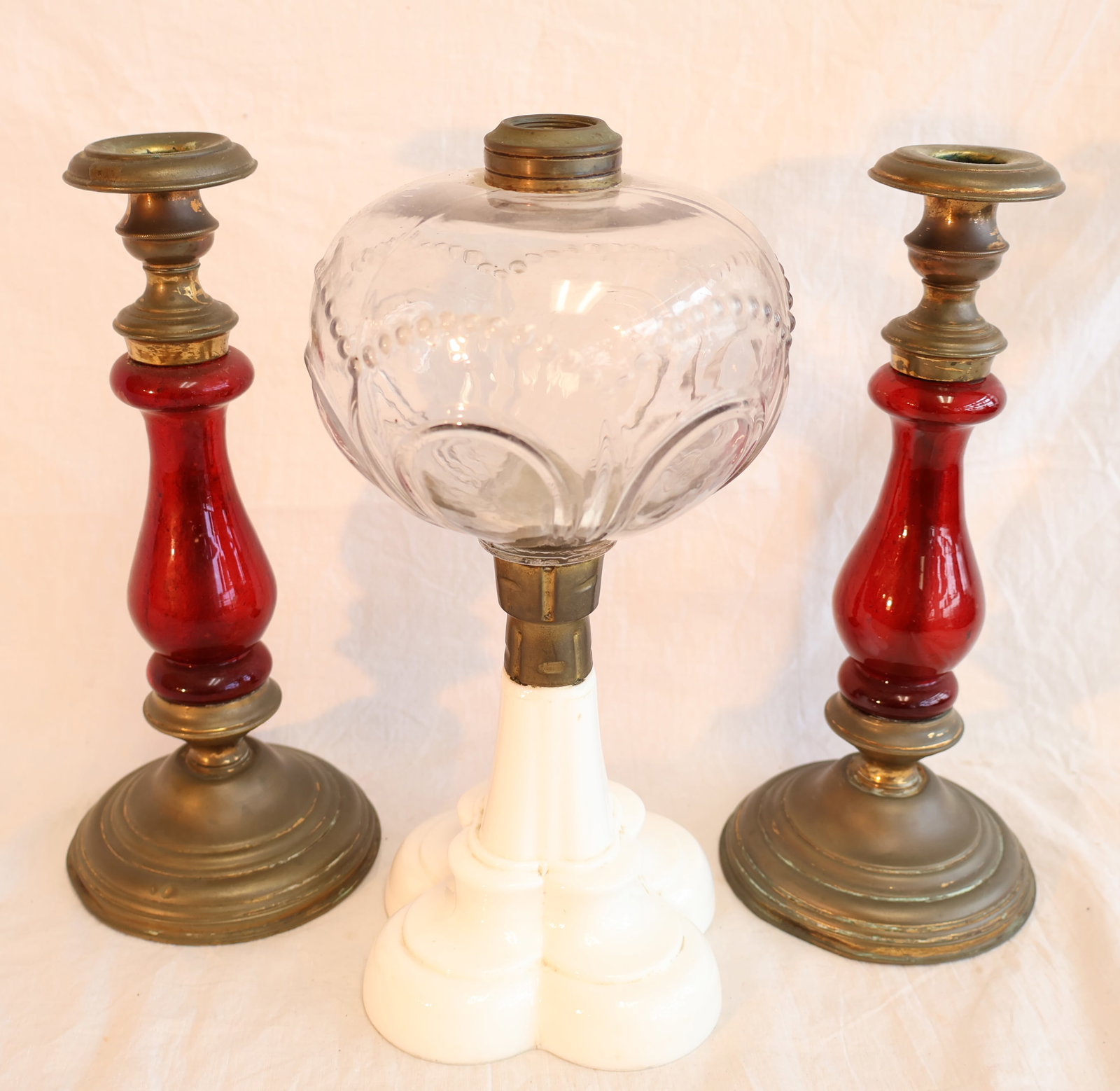 Lot of Three Lighting Devices: One Milk Glass Oil Lamp & a Pair of Candlesticks: Oil lamp: 10 1/2" x 5" Candlesticks: 9 3/4" x 4 1/4" at base Gurley Auction Company provides In House Packing and Shipping and strive to keep costs as reasonable as possible. Please take the time to r