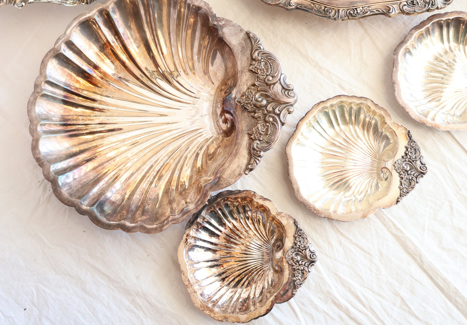 Large Lot of Baroque Pattern Silver Plate by Wallace: 4 Baroque Shell Dishes: 5 1/2" x 5 1/2" 1 Large Baroque Pattern: 11" x 11" 1 Ladle 1 Meat Tray 1 Covered Vegetable Dish Gurley Auction Company provides In House Packing and Shipping and strive to keep