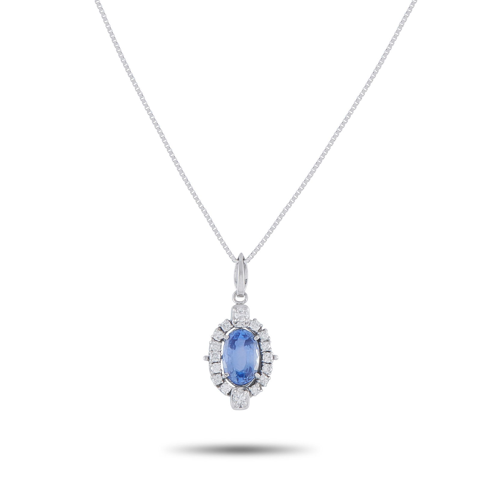 Exclusive Platinum 0.31ct Diamond and Sapphire Oval Halo Pendant: A modern heirloom. This Exclusive necklace features a 1.93-carat oval sapphire, its deep blue hue enhanced by the fire of a diamond halo in a negative space setting. The slight separation between the