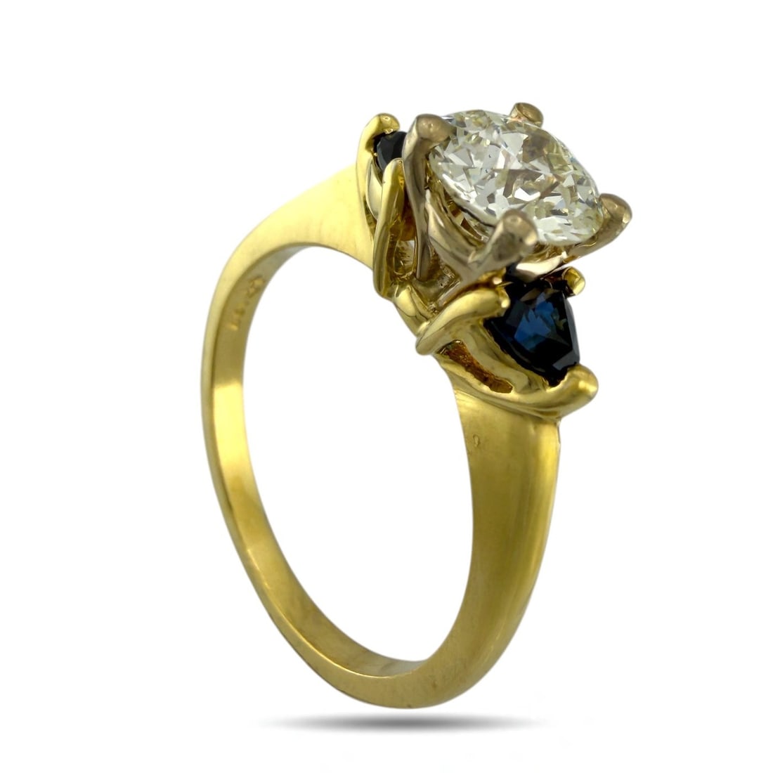 Ring - 18 kt. Yellow gold, Exclusive 18K Yellow Gold 0.90ct Diamond and Sapphire Ring Diamond: Exclusive 18K Yellow Gold 0.90ct Diamond and Sapphire RingAn elegant 18K yellow gold ring featuring a brilliant 0.90 carat center diamond accented by two small triangle cut sapphires. The rich blue sa