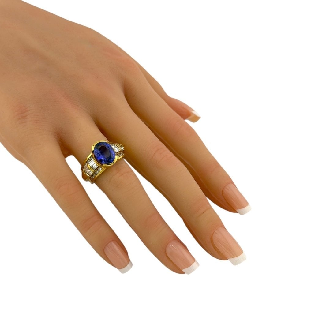 Ring - 18 kt. Yellow gold, 18K Yellow Gold Ring with 0.36ct Diamonds & 2.50ct Tanzanite Sapphire -: 18K Yellow Gold Ring with 0.36ct Diamonds & 2.50ct TanzaniteAn exquisite composition of color and brilliance, this 18K yellow gold ring showcases a captivating 11mm by 8mm tanzanite weighing approxima