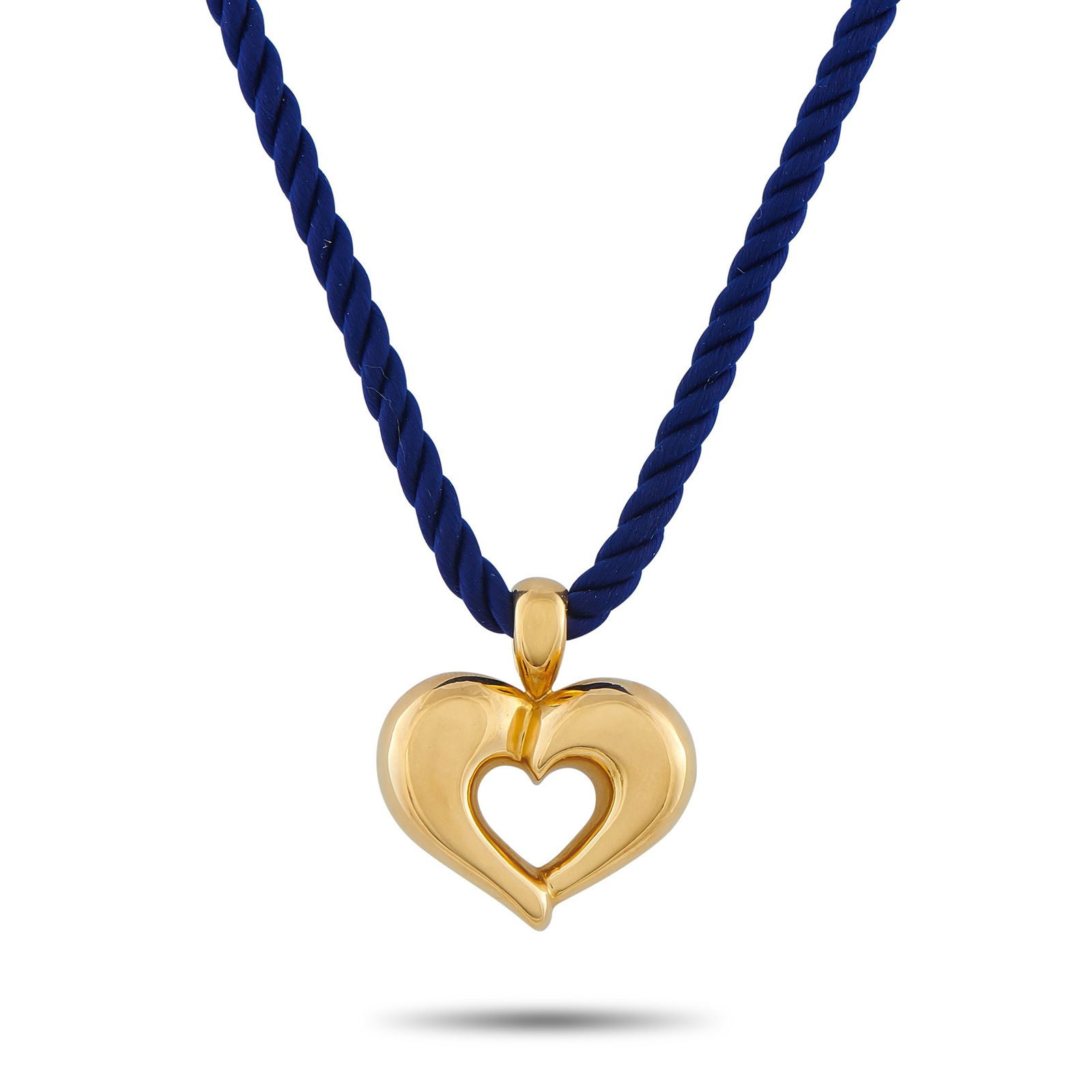 Van Cleef & Arpels 18K Yellow Gold Heart Necklace: A charming and highly wearable statement piece. This Van Cleef & Arpels necklace blends texture and volume with its deep blue rope cord that holds a slightly chunky 18K yellow gold heart pendant, beau