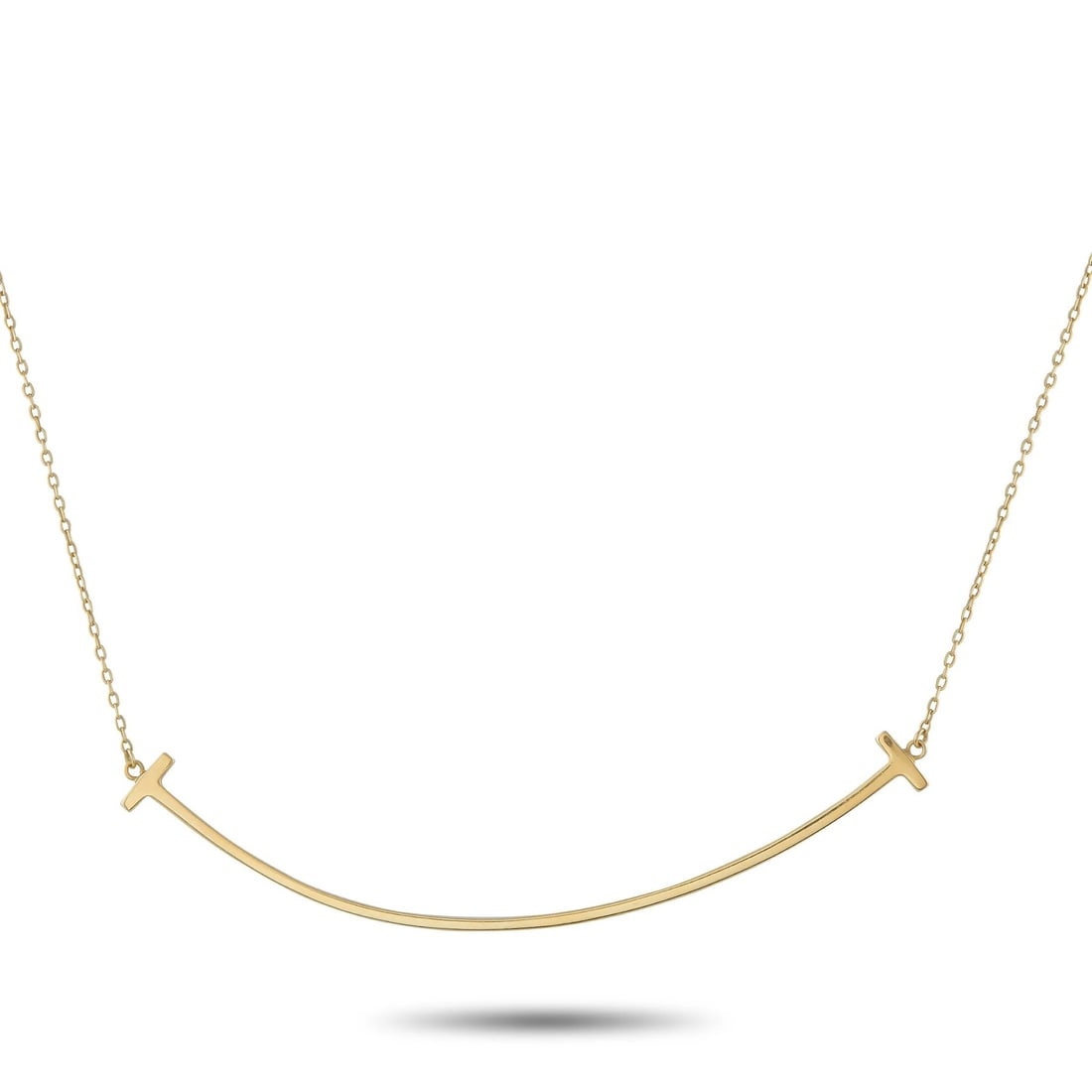 Tiffany & Co. 18K Yellow Gold T Smile Necklace: Tiffany & Co. 18K Yellow Gold T Smile Necklace This Tiffany & Co. T Smile necklace celebrates the luxury brand’s most iconic motif. Suspended at the center of a 17” chain, a curved T-shaped pe