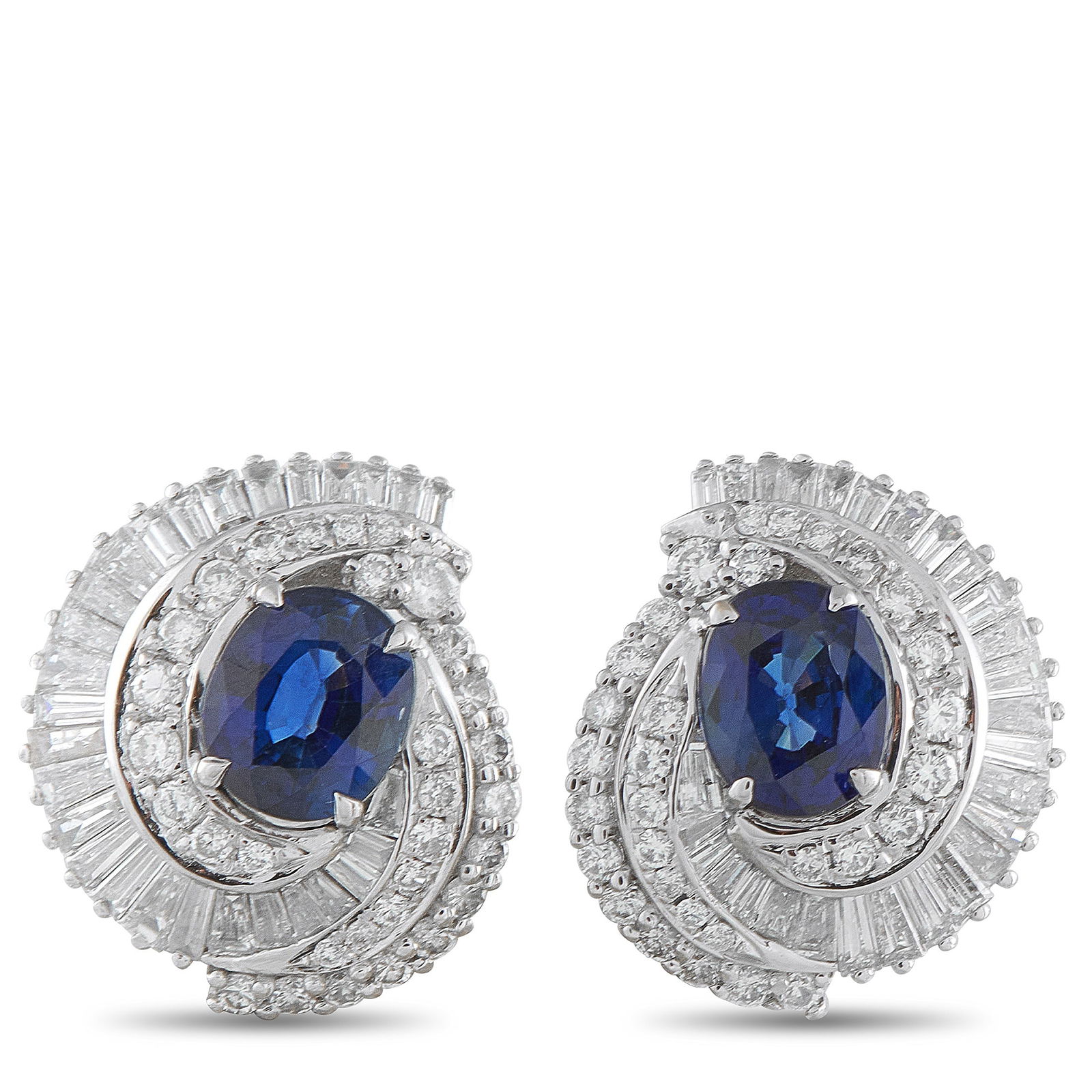 Platinum 1.50ct Diamond and Sapphire Earrings: Rich color and a swirl of brilliance mark these earrings. Each features an oval sapphire in a deep, royal blue hue, embraced by a spiraling halo of diamonds in both round and baguette cuts. The diamon