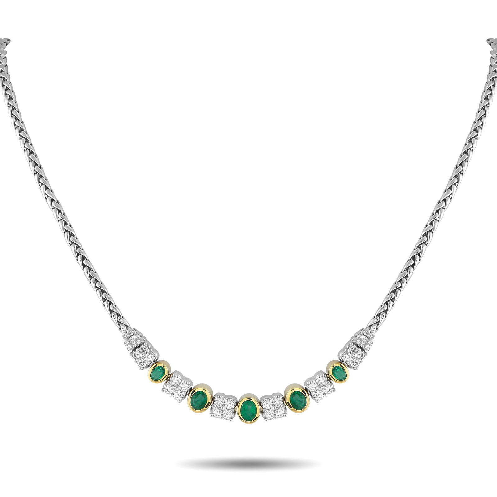 18K White and Yellow Gold 1.65ct Diamond and Emerald Necklace: An exquisite creation of style and presence. This piece features a substantial woven chain, polished in the style of a wheat braid, that lends texture and strength. At its center are tapering oval eme