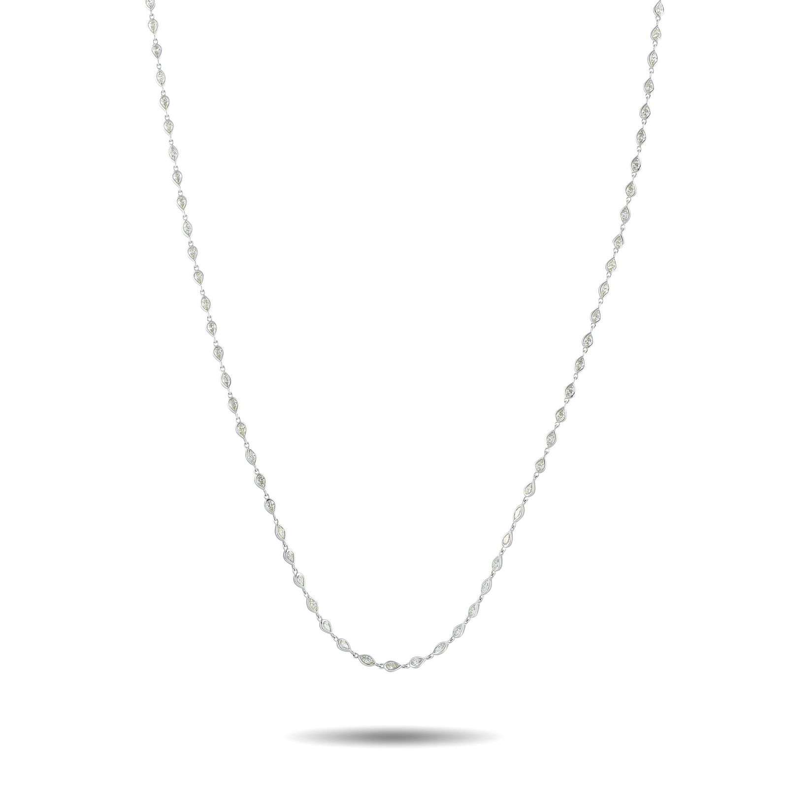 18K White Gold 7.10ct Diamond Necklace: This 18K White Gold necklace is ideal for any occasion. A series of round-cut Diamonds totaling 7.10 carats shine to life from their place within a sleek bezel setting. A dramatic 28” length mak