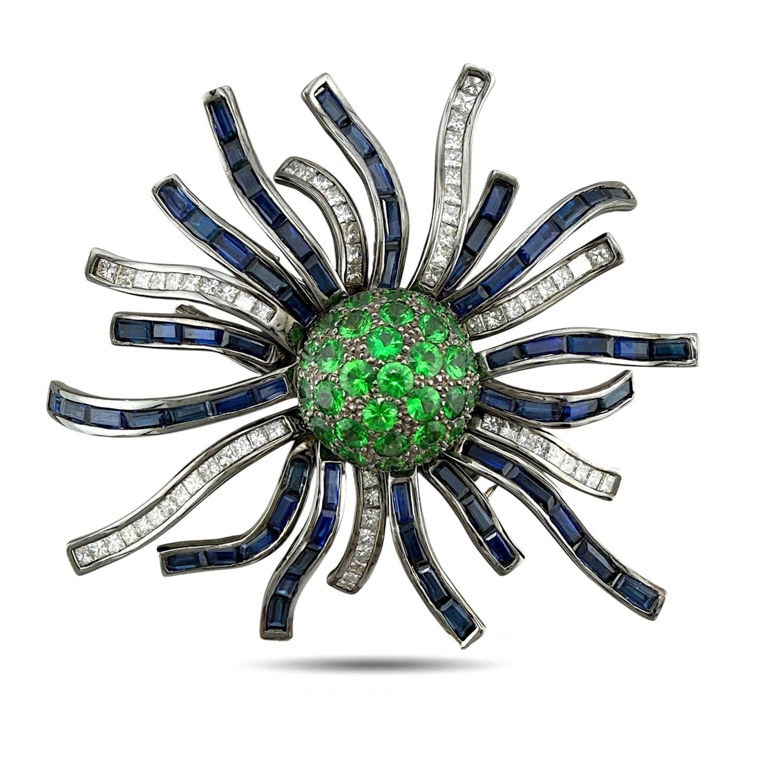 18 kt. Exclusive 18K White Gold 2.64ct Emerald, 1.64ct Diamond & Sapphire Brooch, White gold Diamond: Exclusive 18K White Gold 2.64ct Emerald, 1.64ct Diamond & Sapphire BroochAn exceptional and sculptural brooch crafted in luminous 18 karat white gold, designed in an intricate woven motif radiating ou