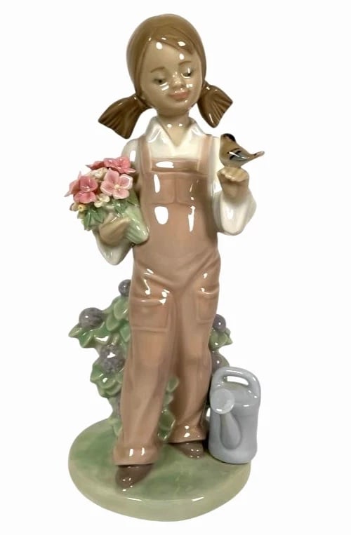 LLADRO SPRING PORCELAIN FIGURINE 5217: LLADRO SPRING PORCELAIN FIGURINE 5217Lladro porcelain figurine titled 'Spring Girl,' reference number 5217. Features a young girl holding a bird and a bouquet of flowers while standing beside a wateri