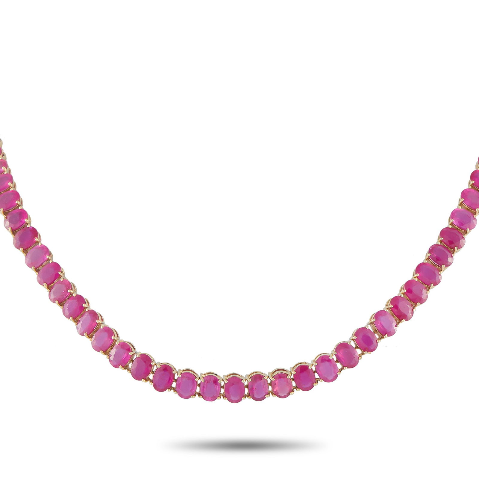 18K Yellow Gold 65.0ct Ruby Line Necklace: This line necklace is designed as a continuous 16-inch sequence of oval rubies totaling approximately 65.0 carats. Each ruby is set vertically in a classic four-prong mount with an open back,